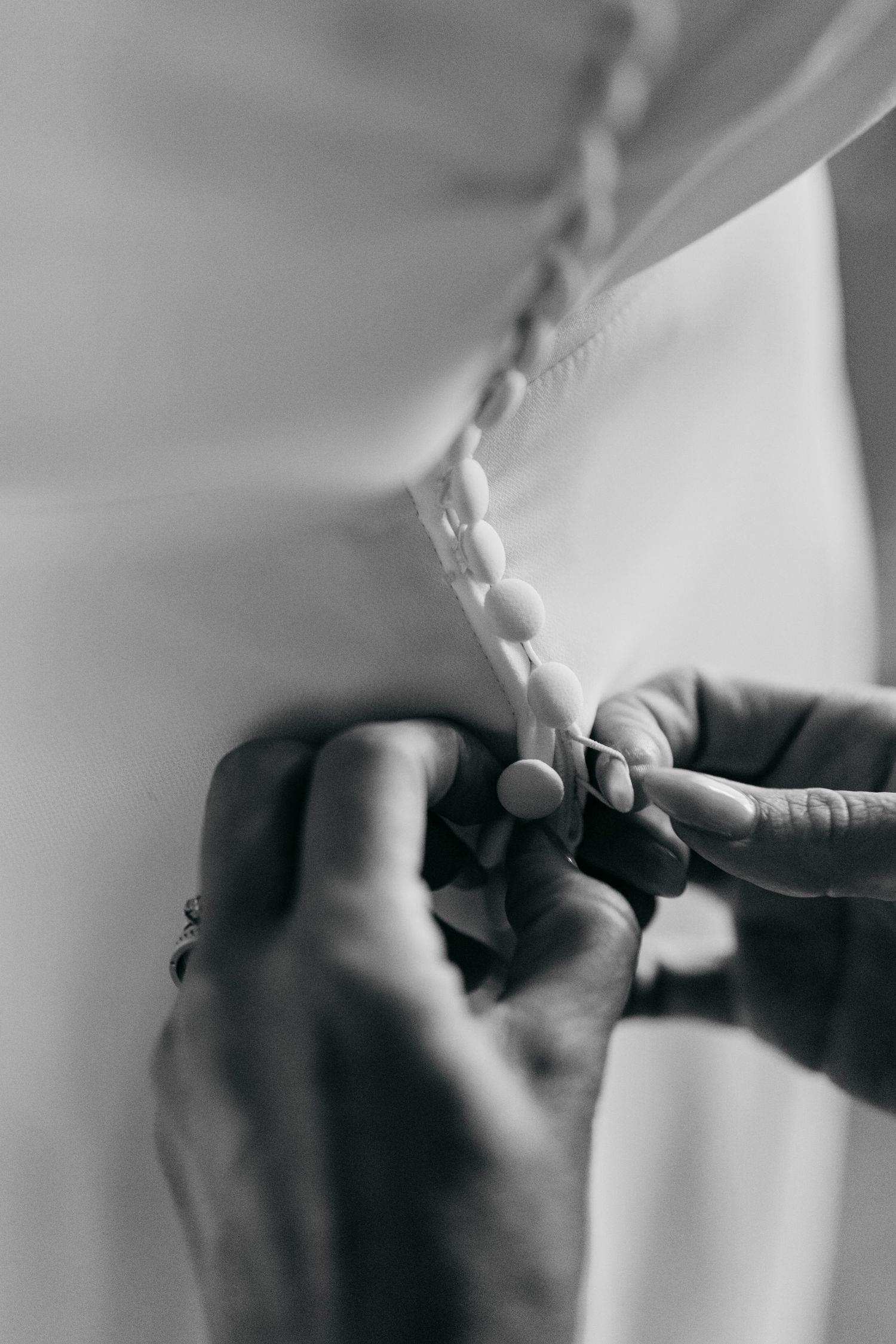 Close-up black and white shot of hands writing or signing a document.