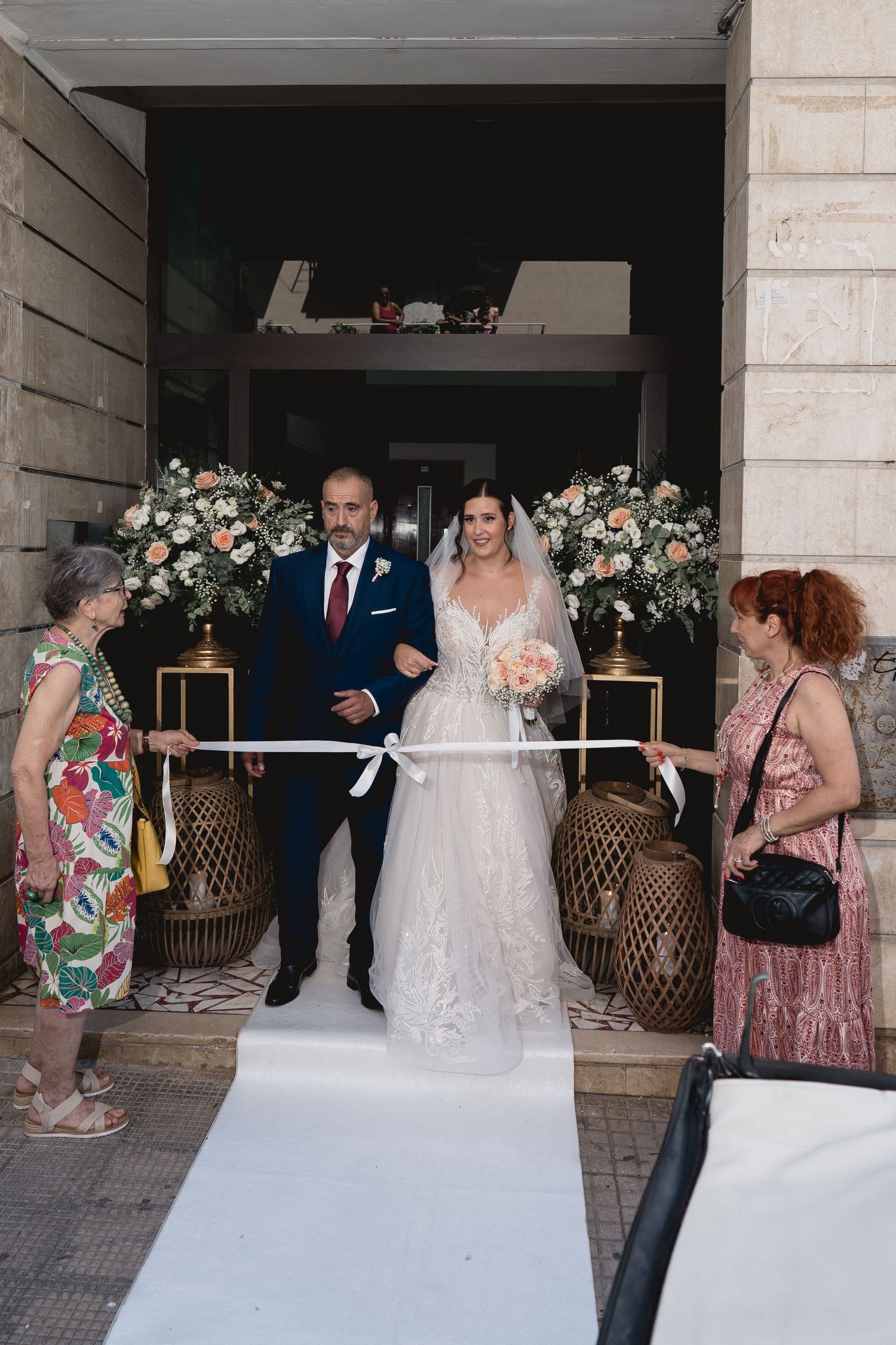 A wedding entrance decorated with floral arrangements and wicker baskets.