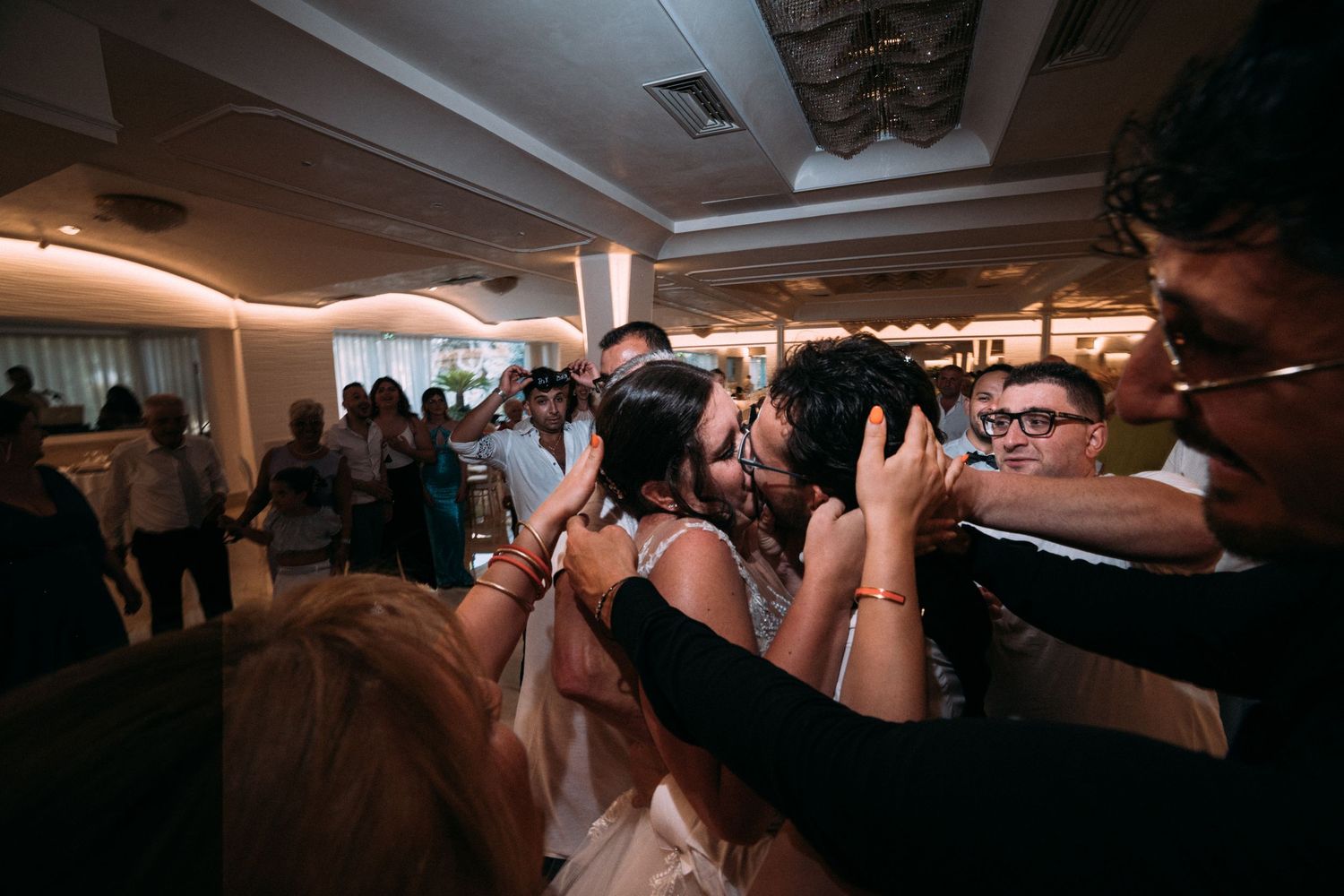 Wedding photographers capturing moments during the reception on a crowded dance floor.