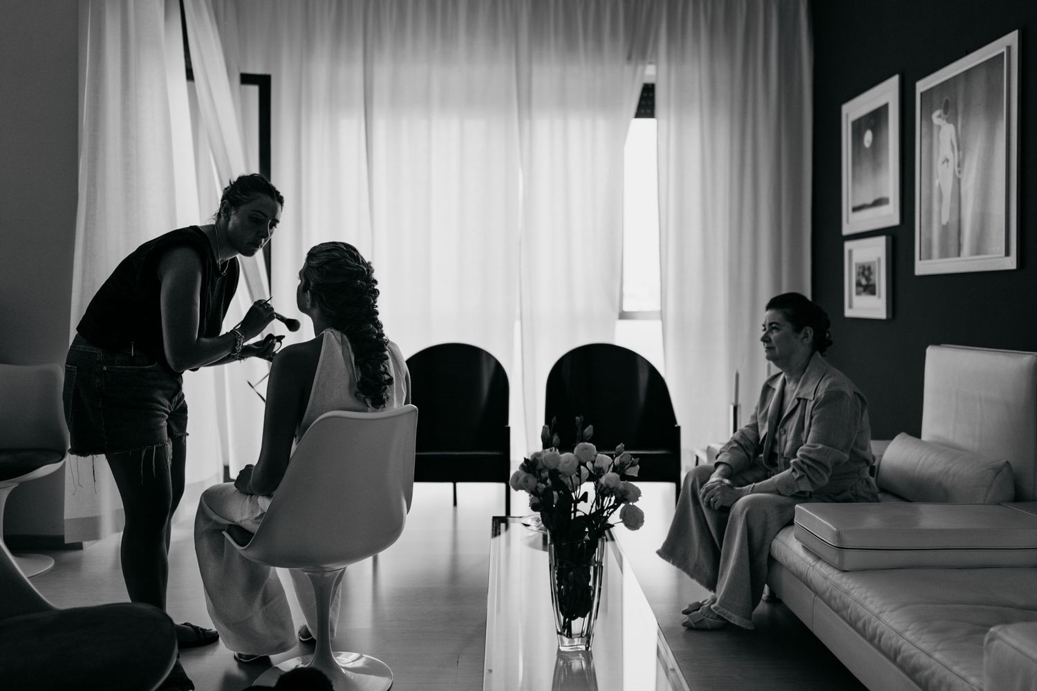 Black and white photograph showing a group gathered in an elegant room with flowers.