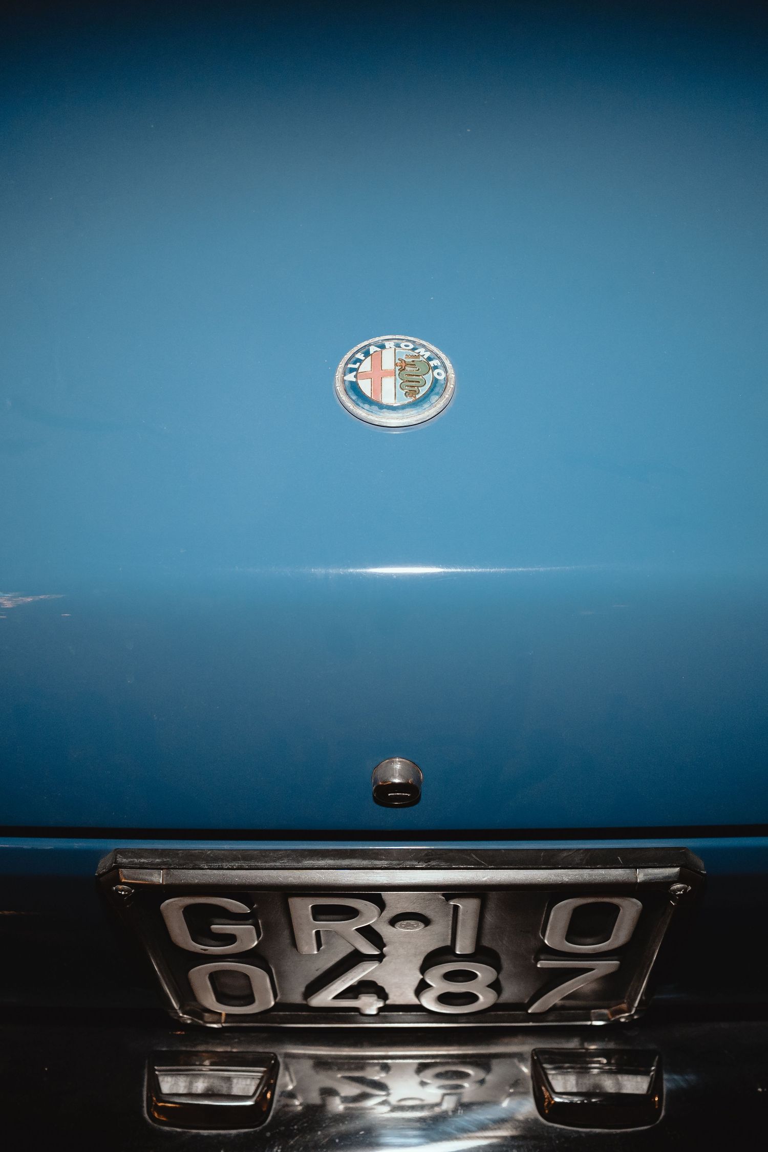 Close-up detail shots of a classic blue car's chrome trim and badges against a dark background.