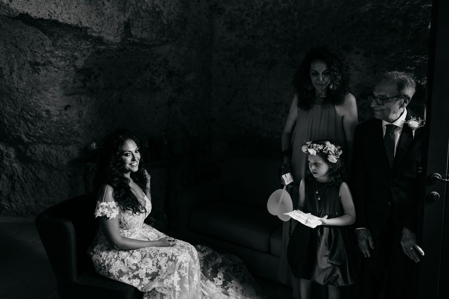 Dramatic black and white wedding photography in stone corridor.