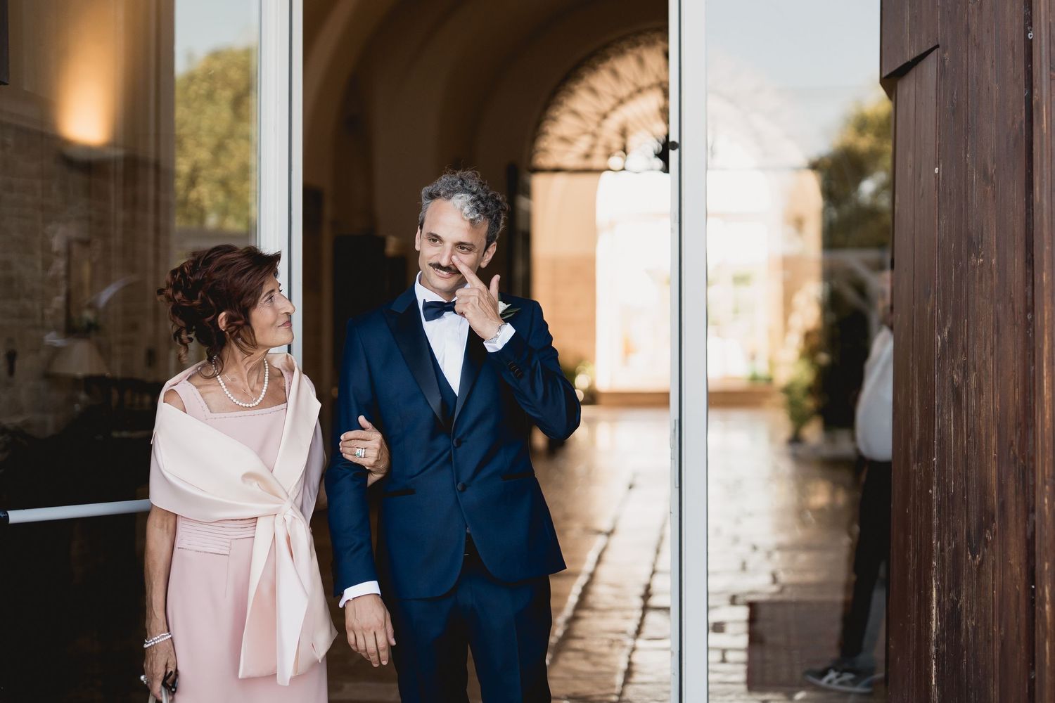 Couple sharing a tender moment while walking together under an archway.
