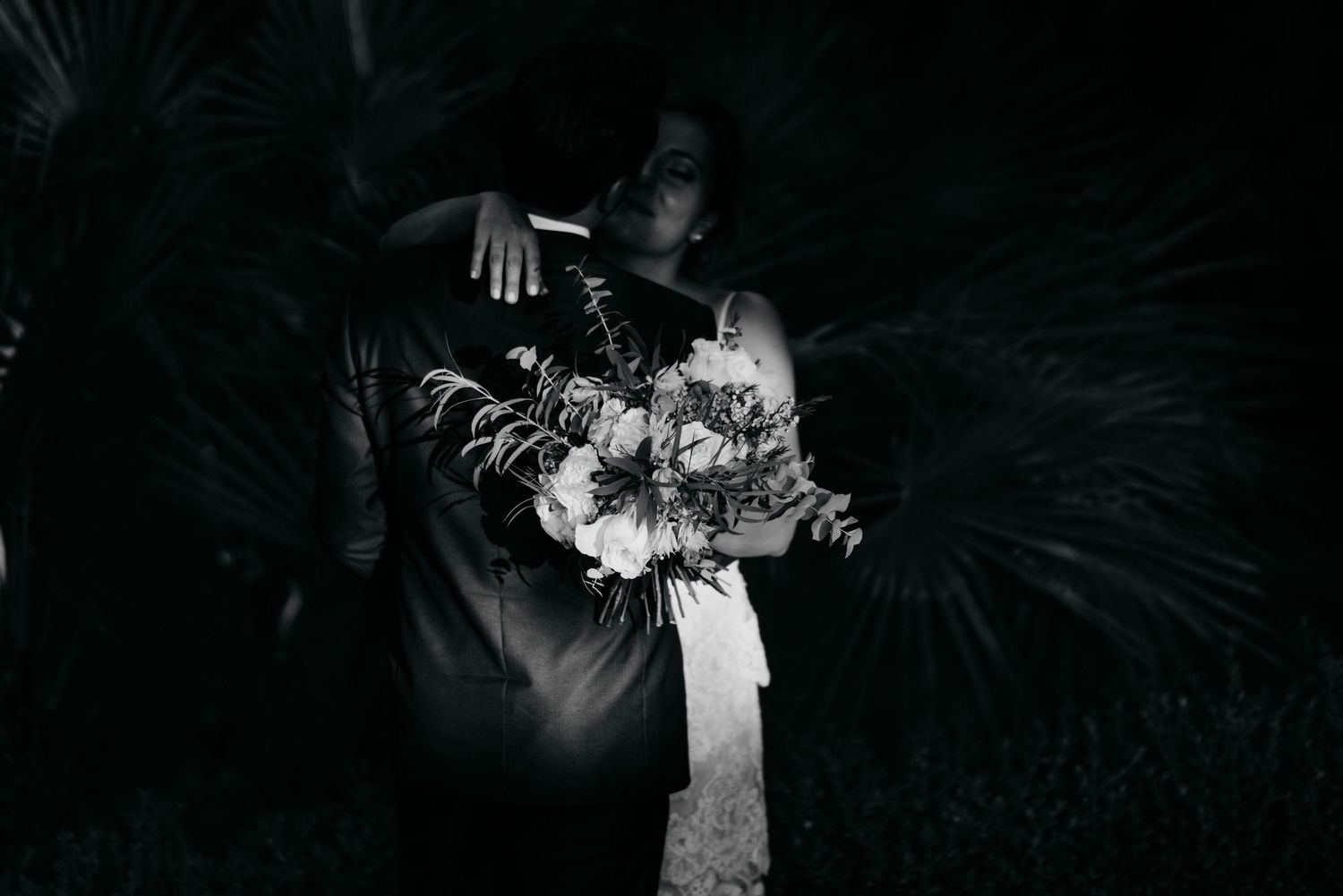A couple shares a romantic dance outdoors at night with dramatic lighting creating a magical atmosphere.