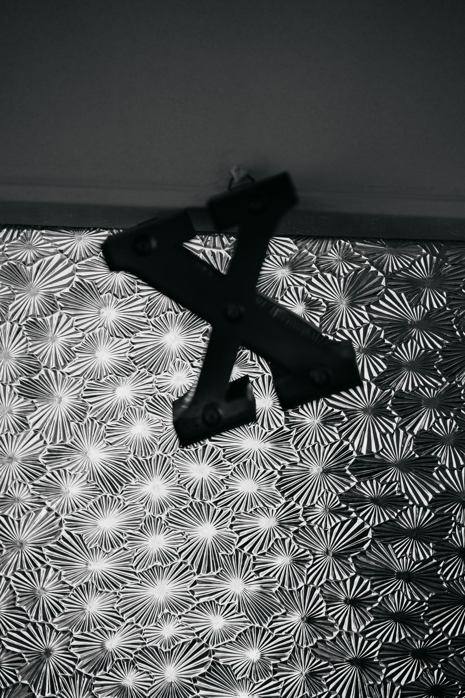 Black and white image of lingerie on a patterned geometric background.