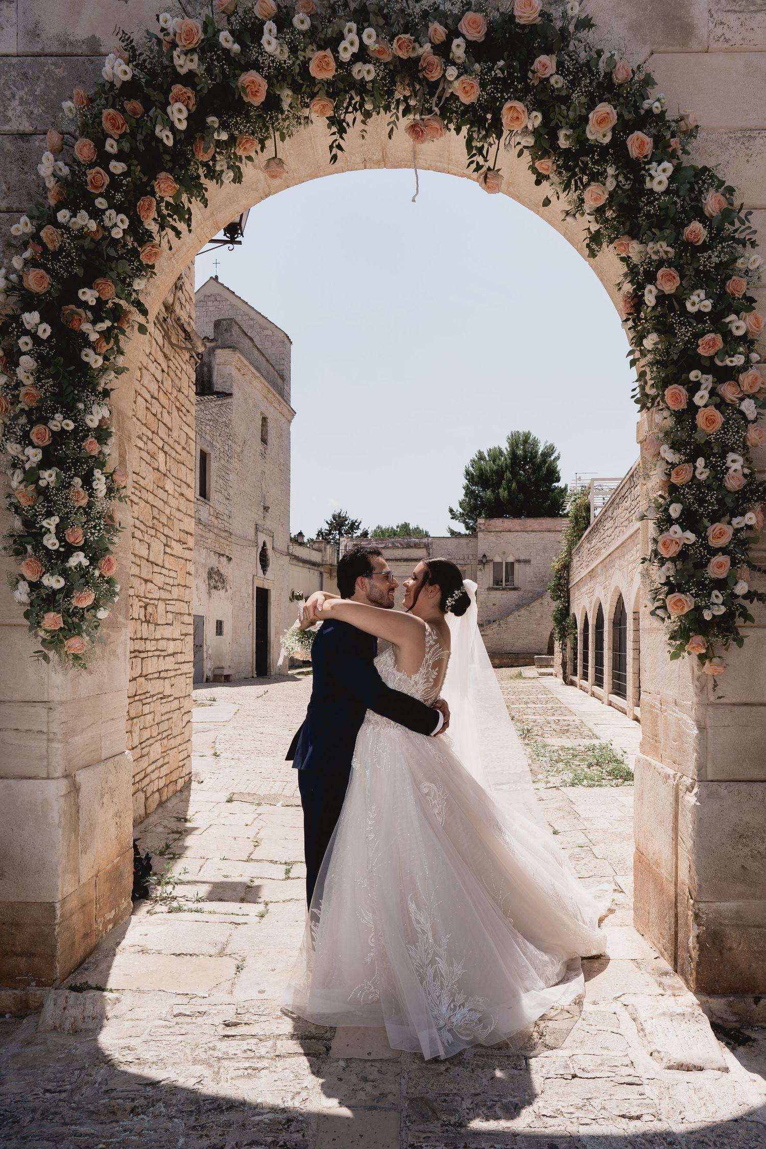 A intimate wedding moment captured outside a Mediterranean-style building.