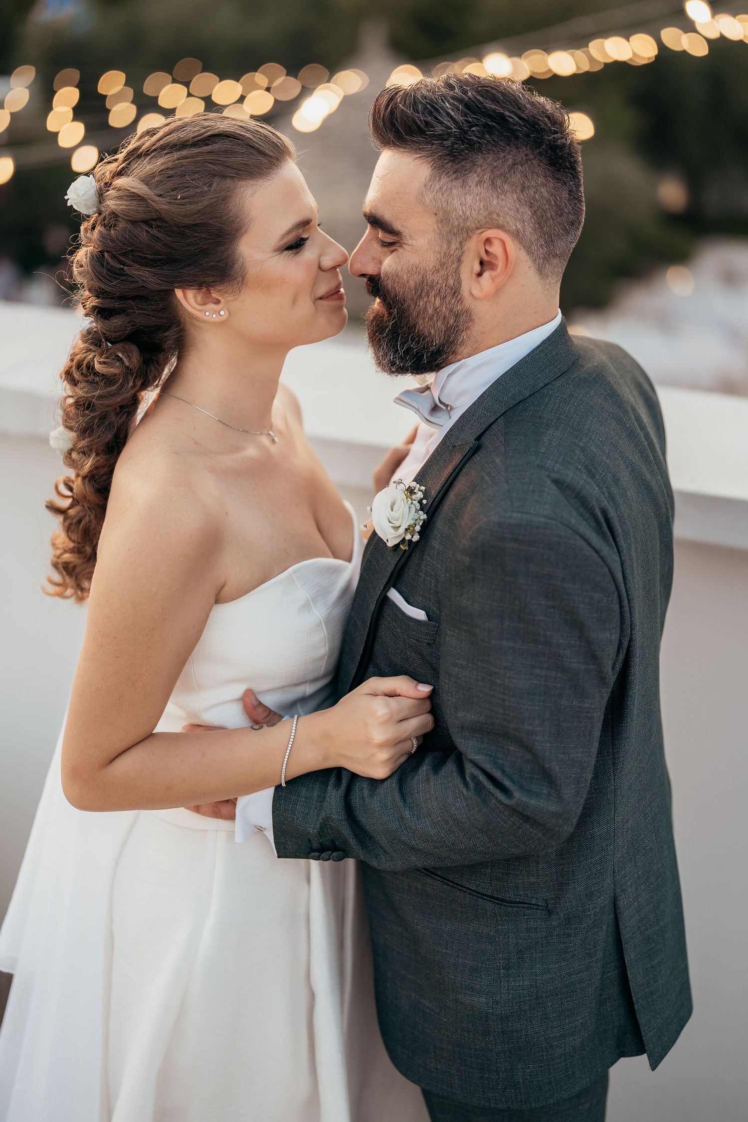 A romantic moment between newlyweds with soft bokeh lights in the background.