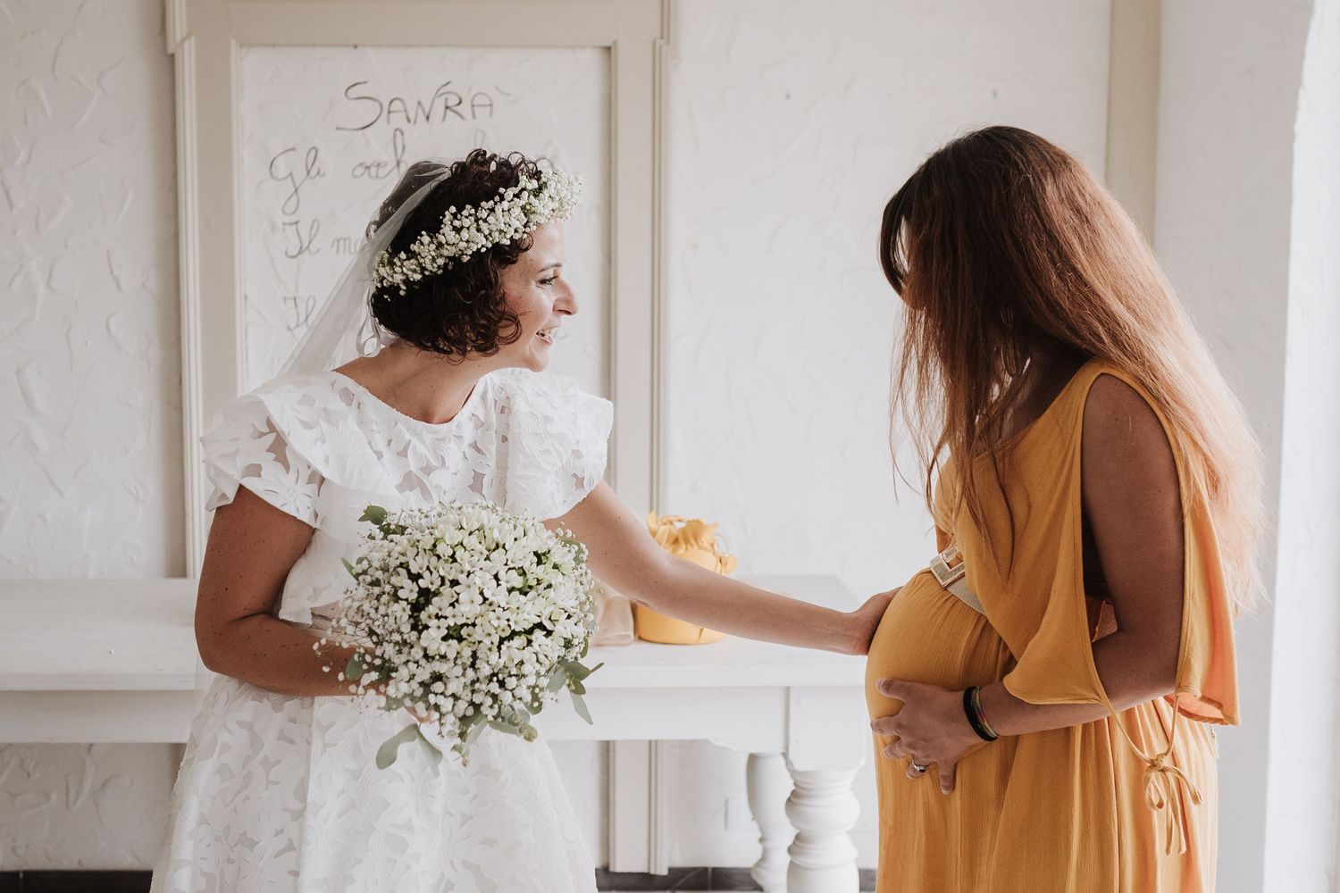 Intimate moment between two people during a wedding, one wearing white lace and a flower crown.