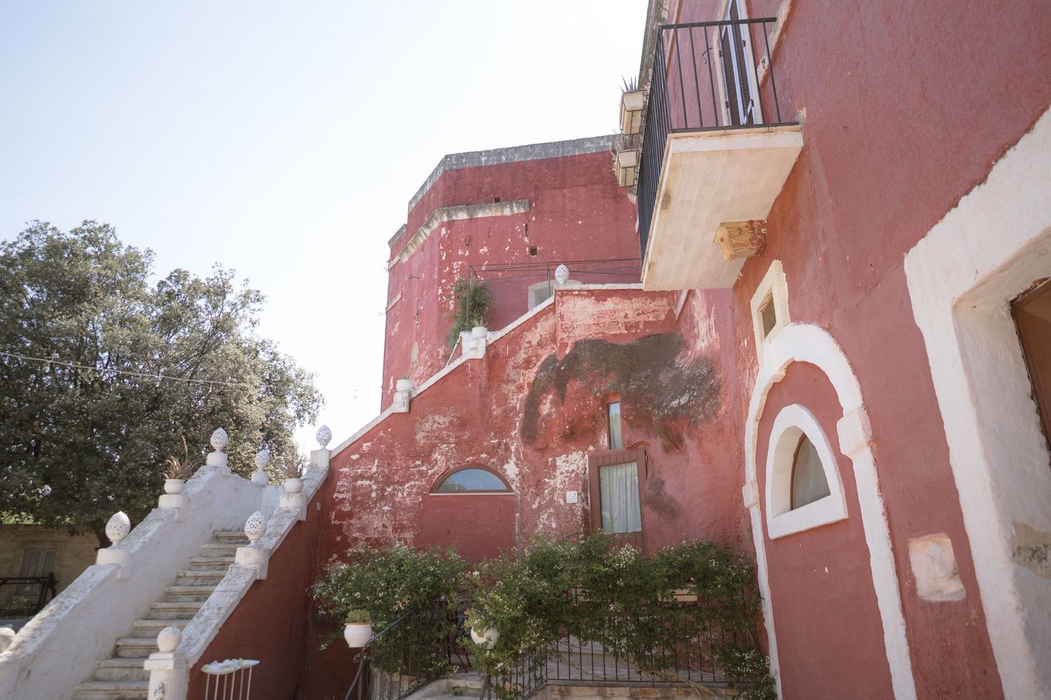 Exterior view of a rustic pink-colored building with white architectural details.