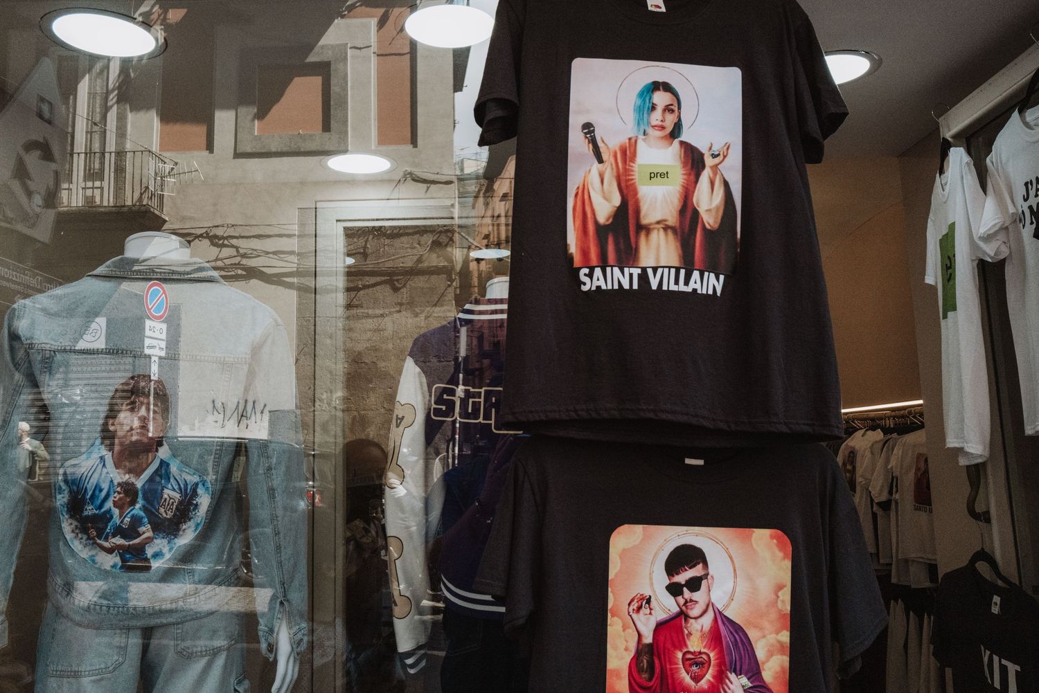 Retail clothing display showing graphic t-shirts with music-themed designs hanging in a store.