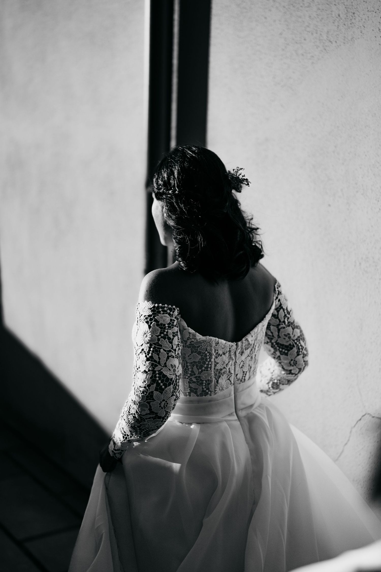 Black and white detail shots focusing on the back of an intricate lace wedding dress.