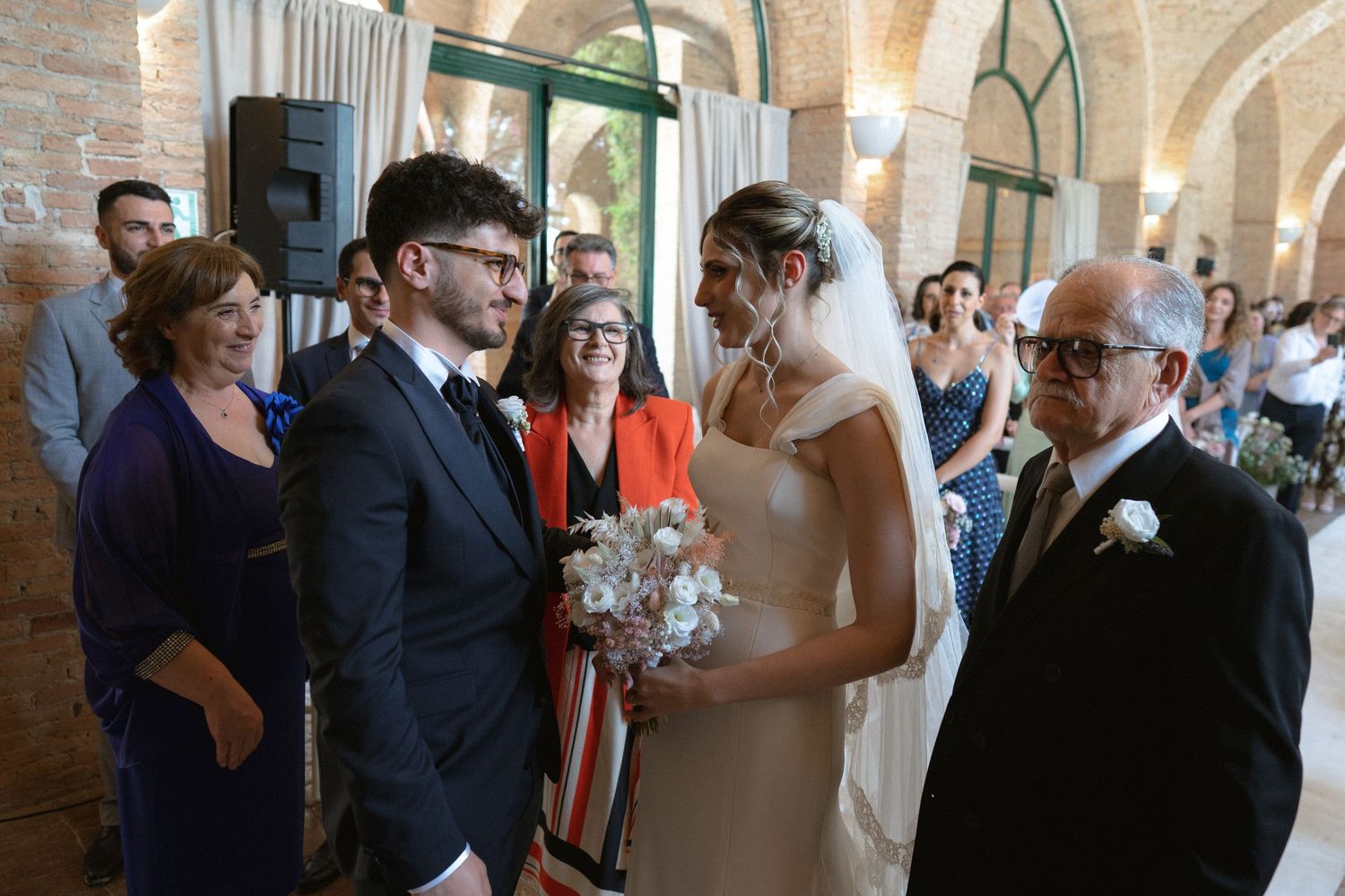 Wedding guests gathered in an elegant stone archway venue during celebration.