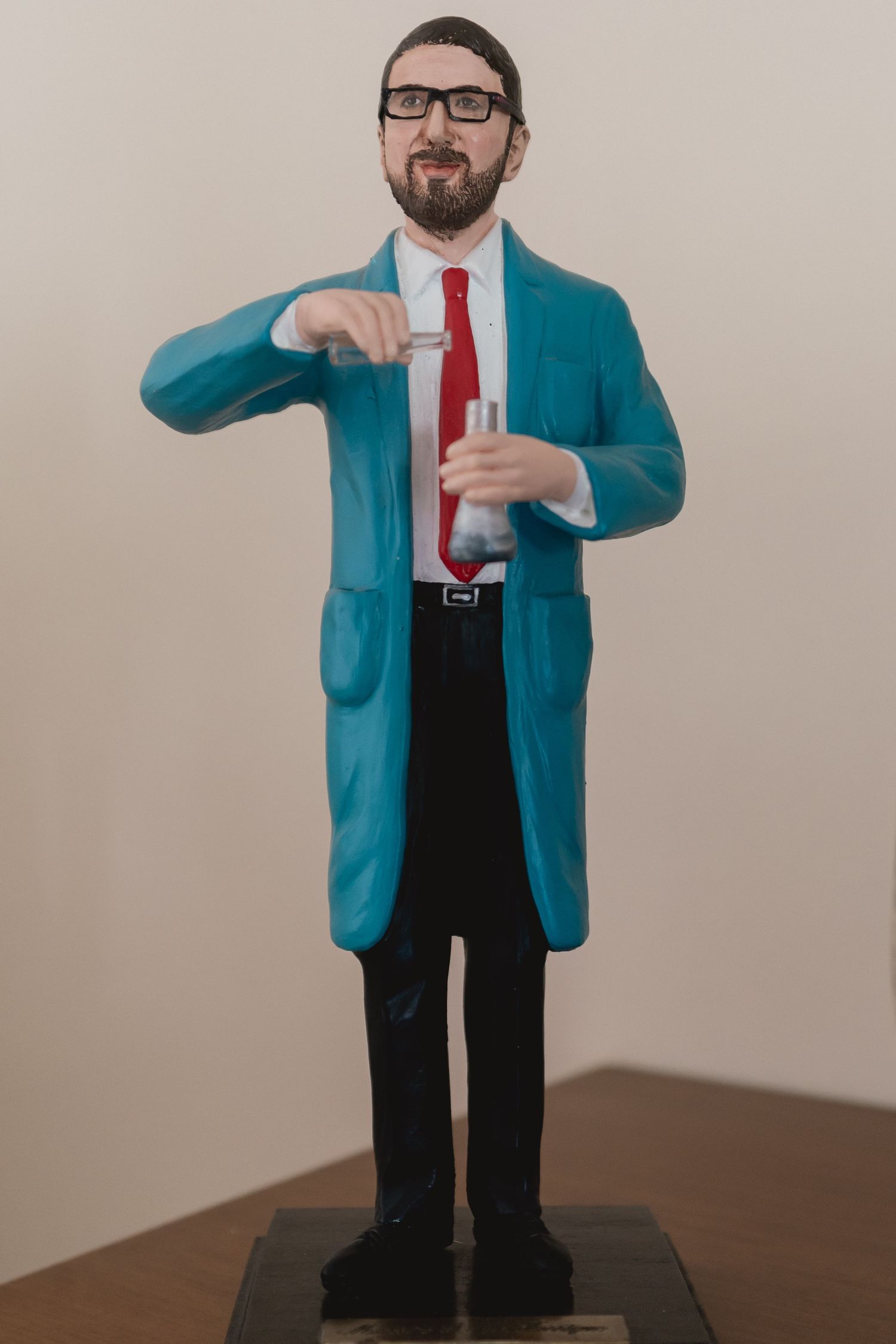 Decorative figurine wearing a bright turquoise suit and red tie.