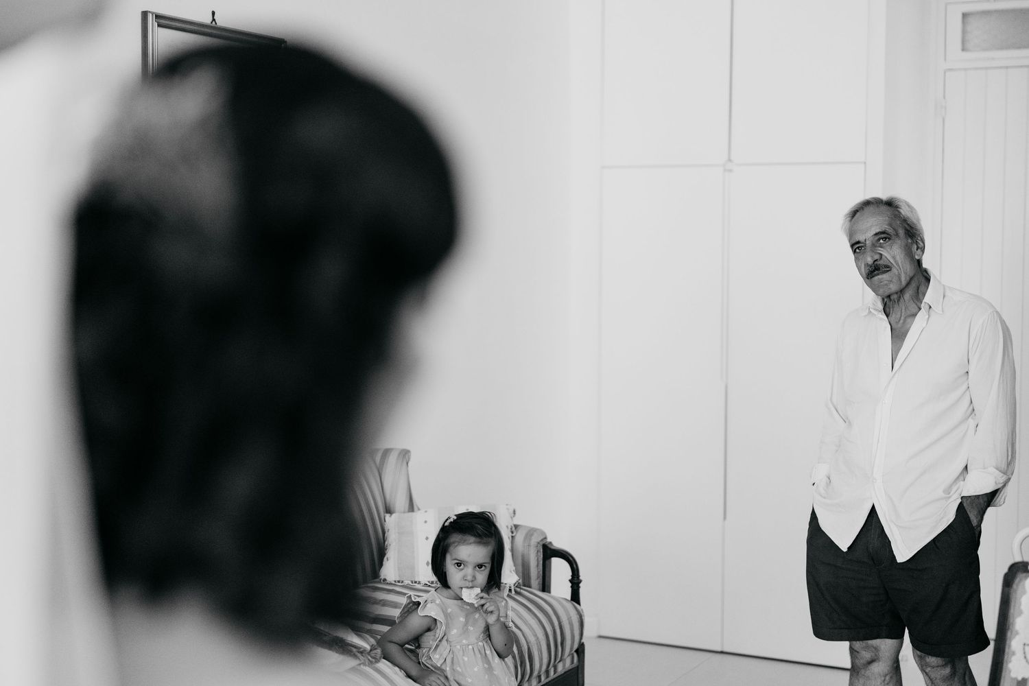 Wedding party gathered in a bright white room for photos.