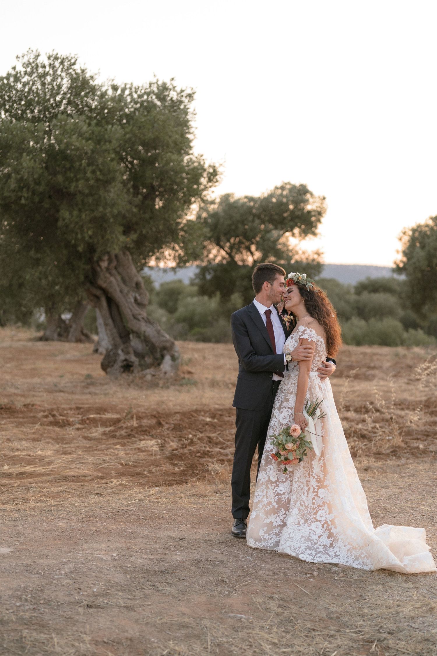 Romantic wedding portraits in an olive grove during golden hour.