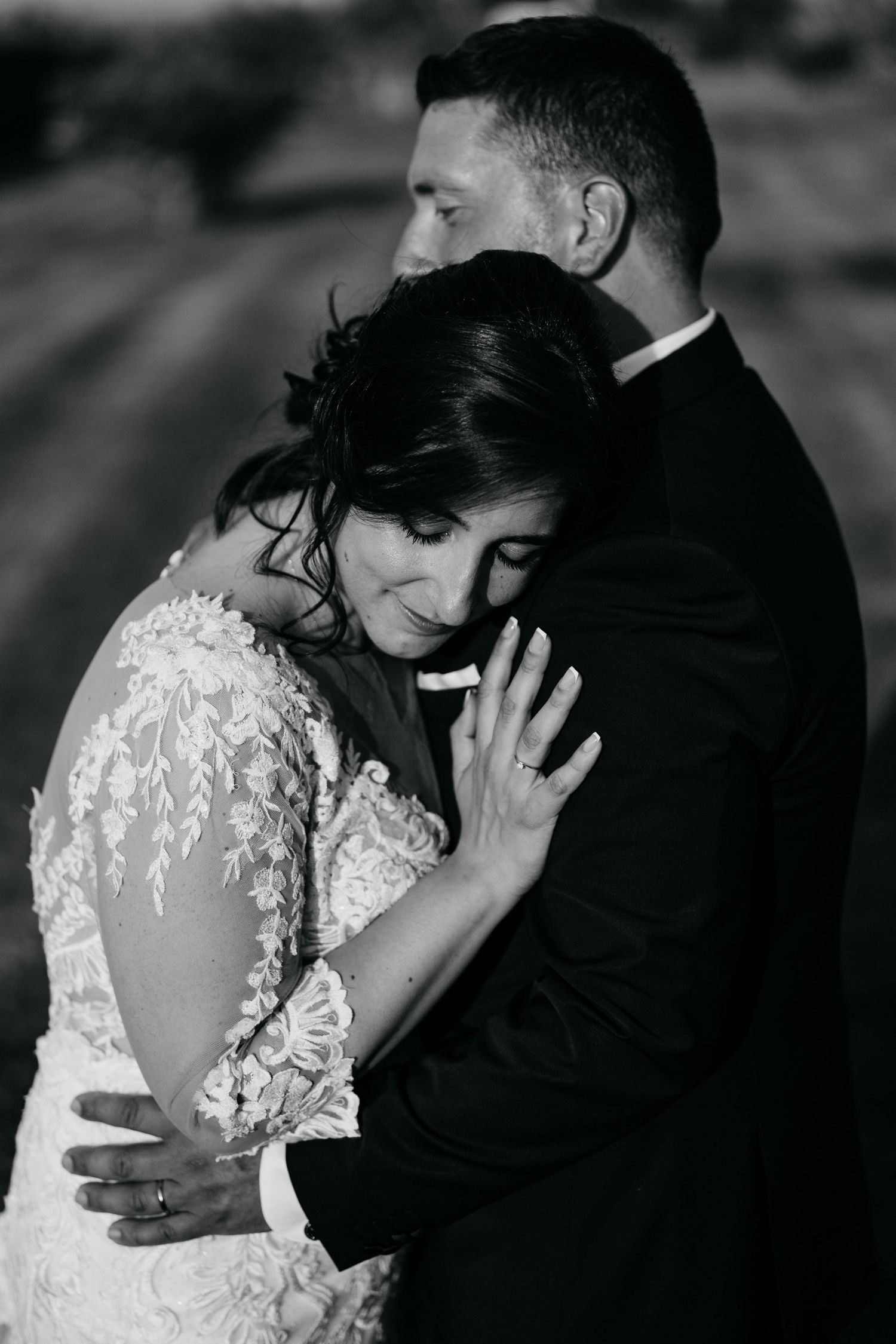 Intimate black and white wedding photos showing tender moments between newlyweds in an emotional embrace.