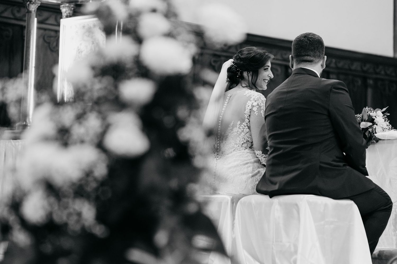 Elegant wedding ceremony entrance decorated with white floral arrangements and columns.