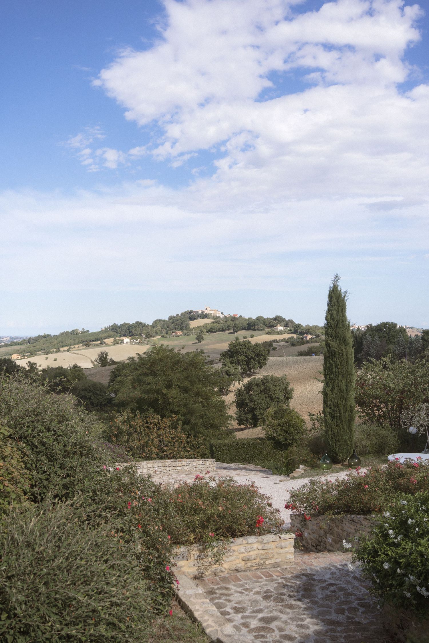 Scenic Tuscan landscape with cypress trees, rolling hills and blue skies.