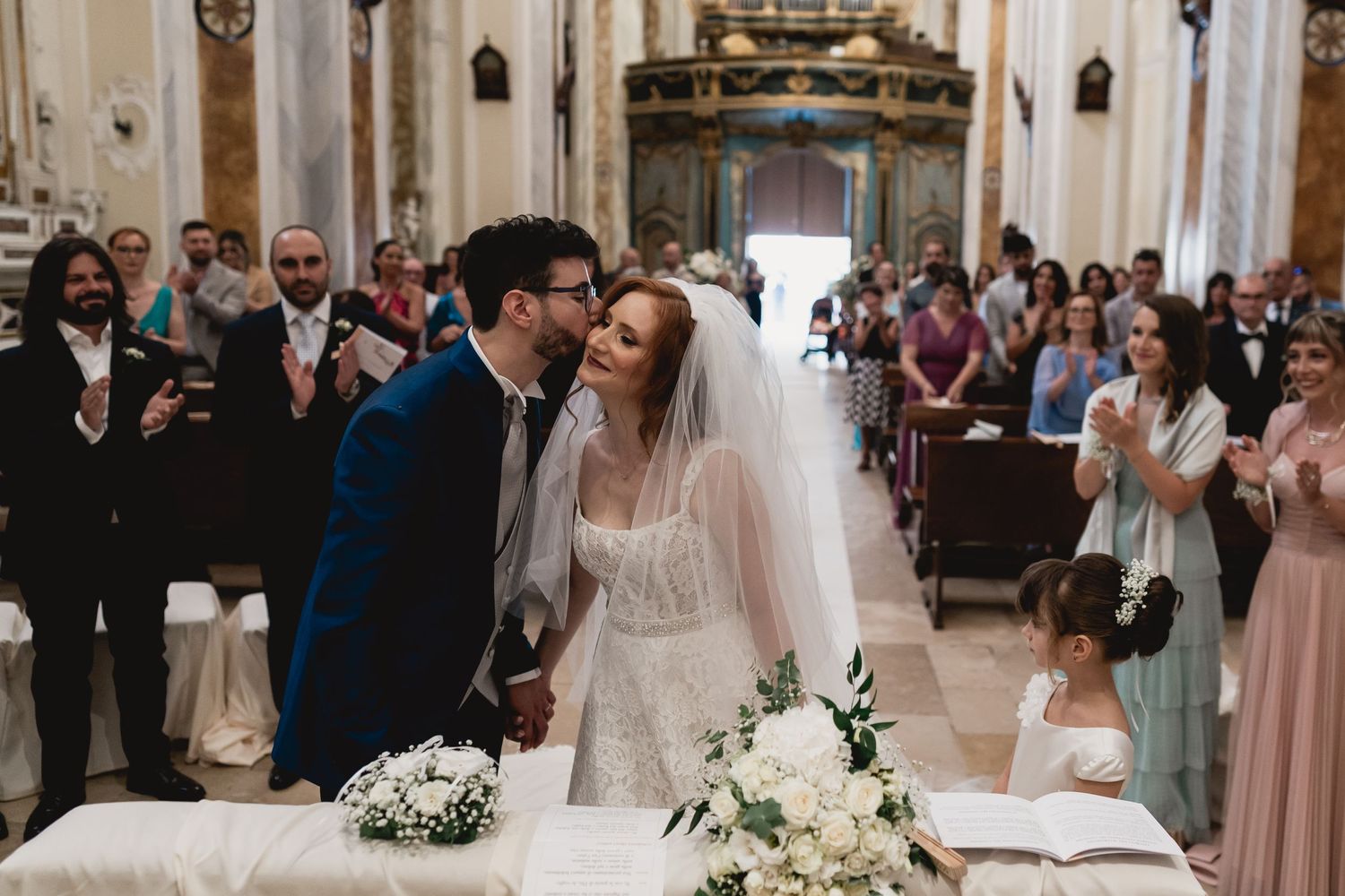 Romantic wedding ceremony moment in beautiful church interior with guests watching.