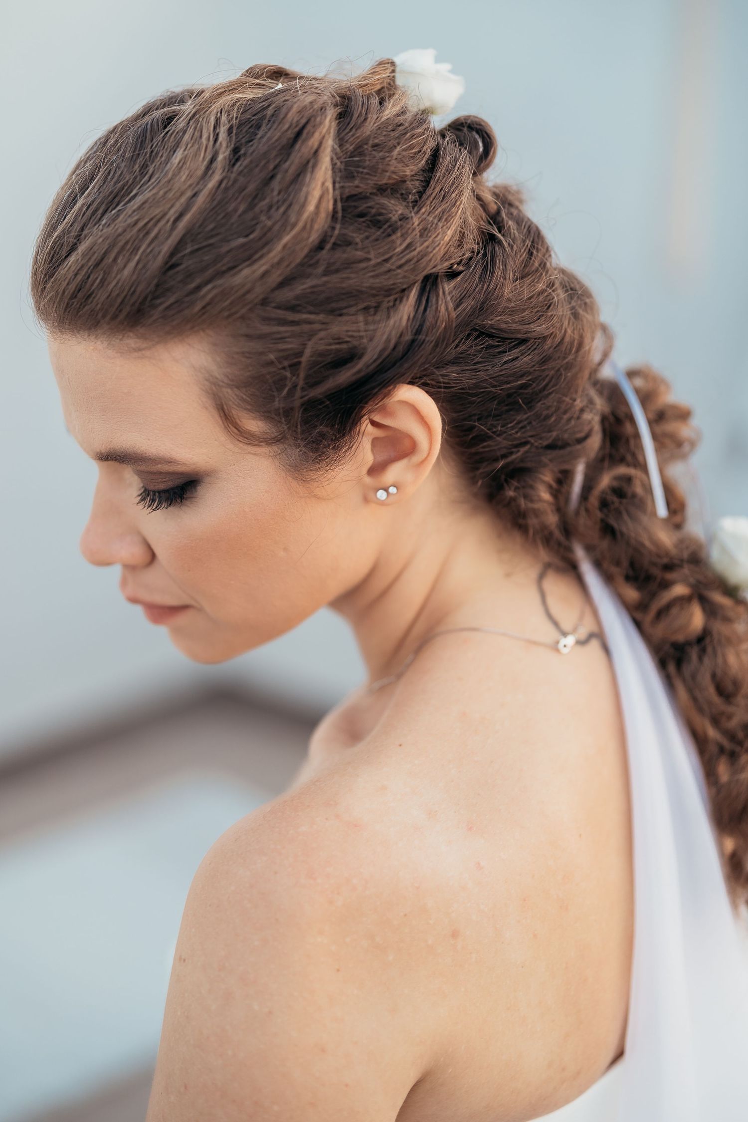 An elegant bridal hairstyle featuring intricate braids and subtle pearl accessories.
