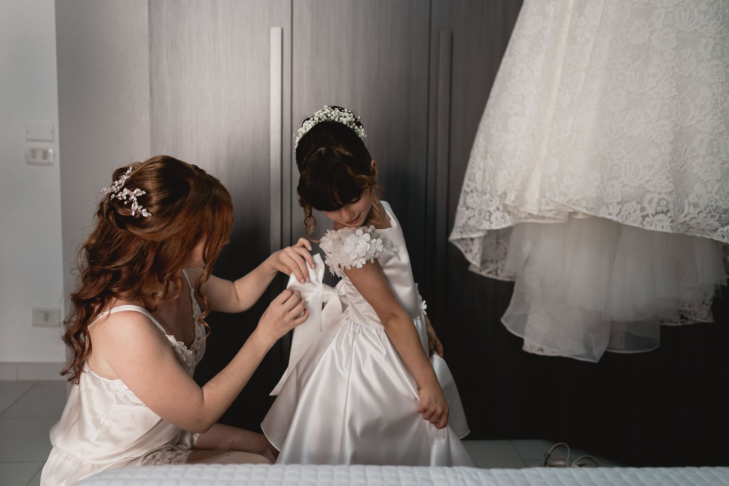 Wedding preparation scene with delicate white dress details.