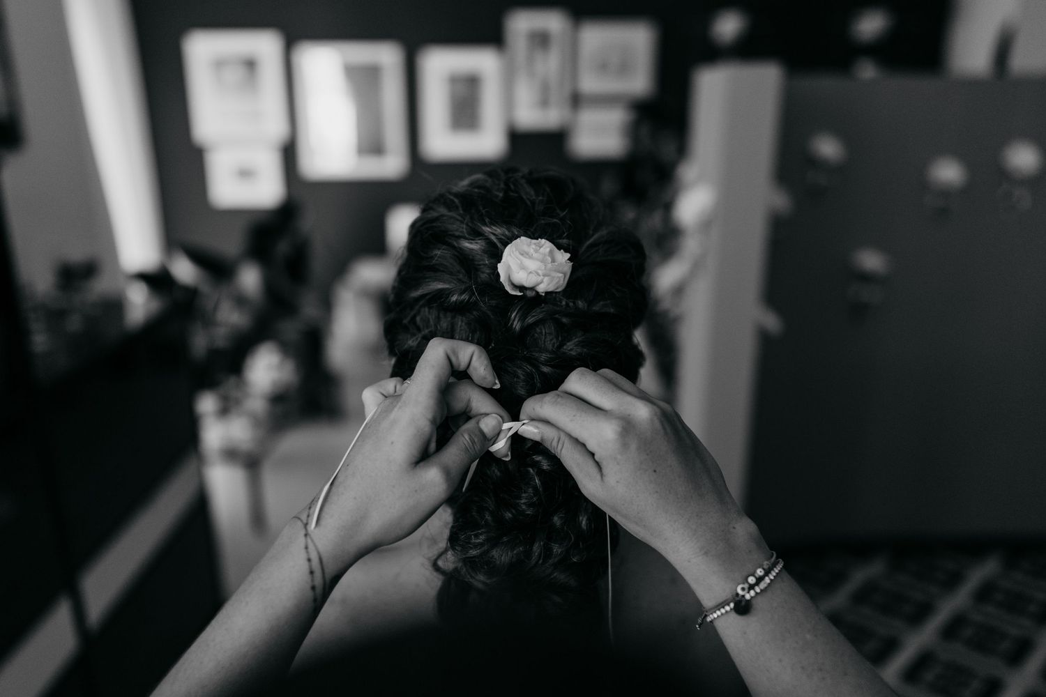 Black and white close-up shot of hands holding a vintage camera in a dimly lit room.