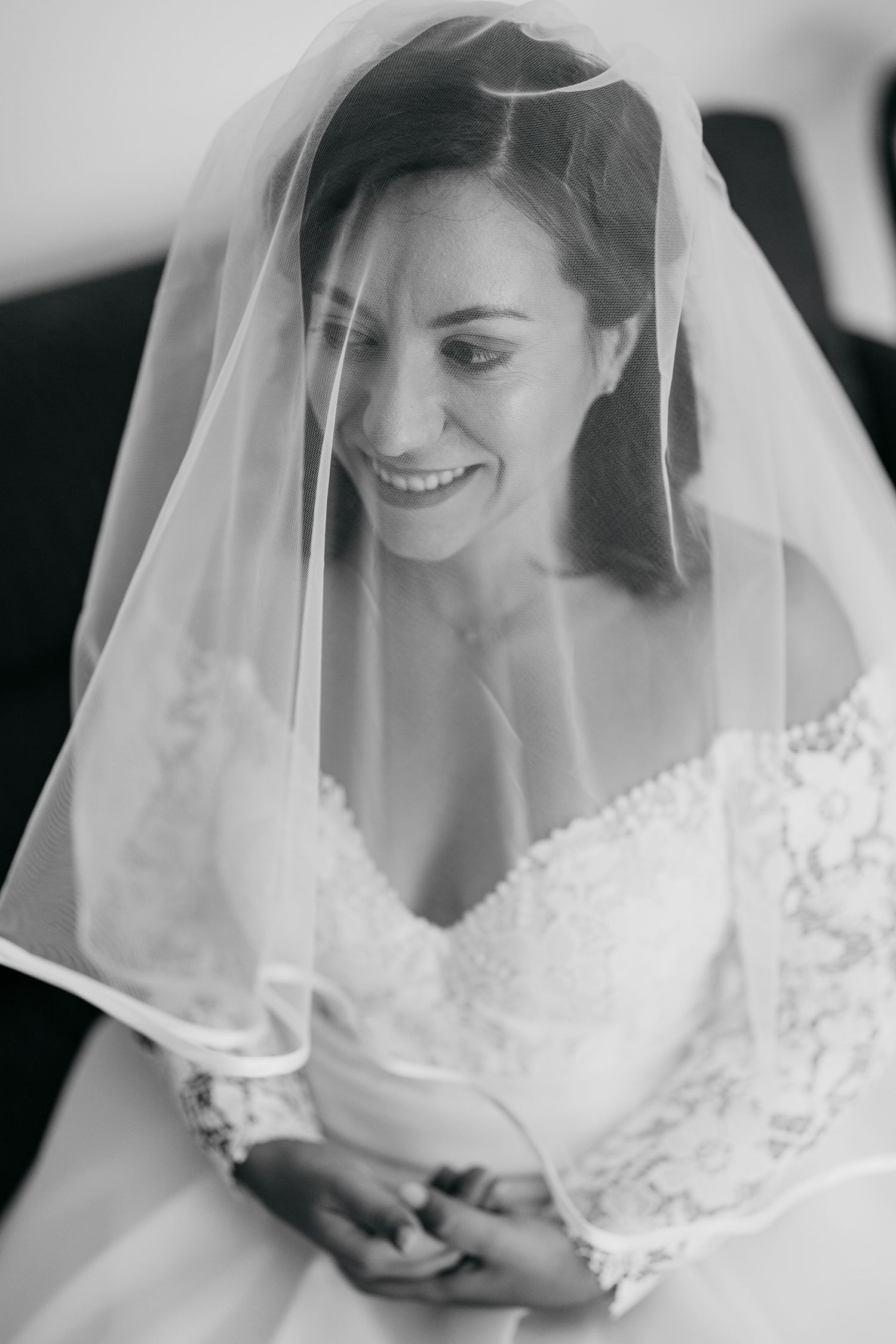 Close-up black and white portraits of a bride wearing a delicate veil showing various expressions.
