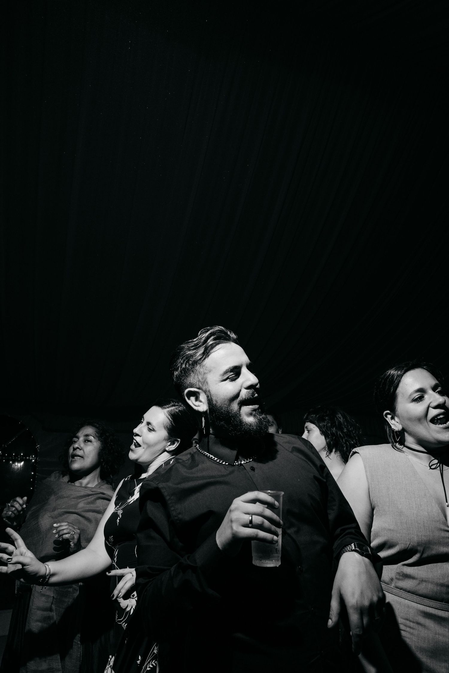 Black and white photo of party guests laughing and celebrating.