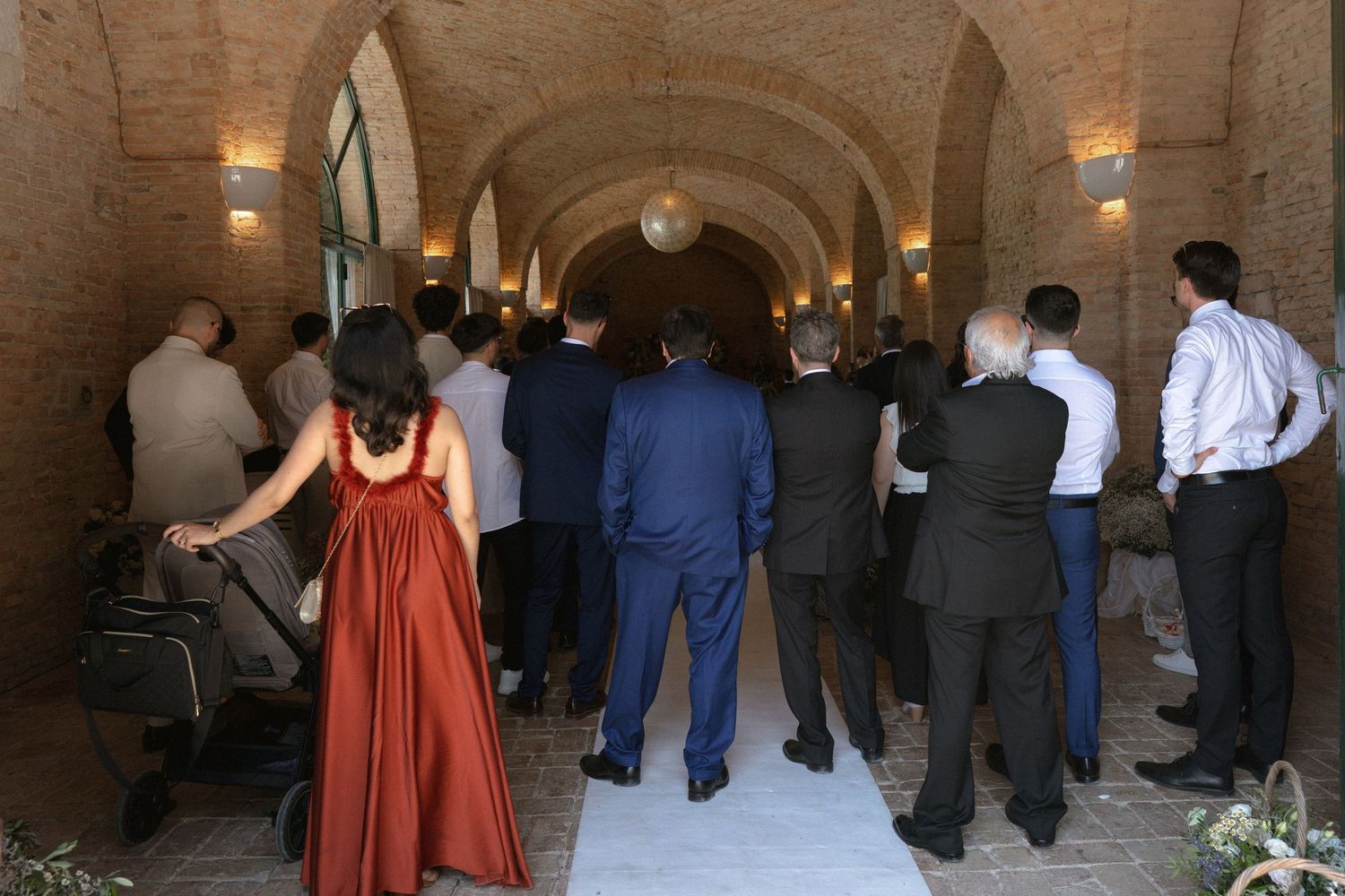 Guests gather under arched stone columns at an elegant event venue.