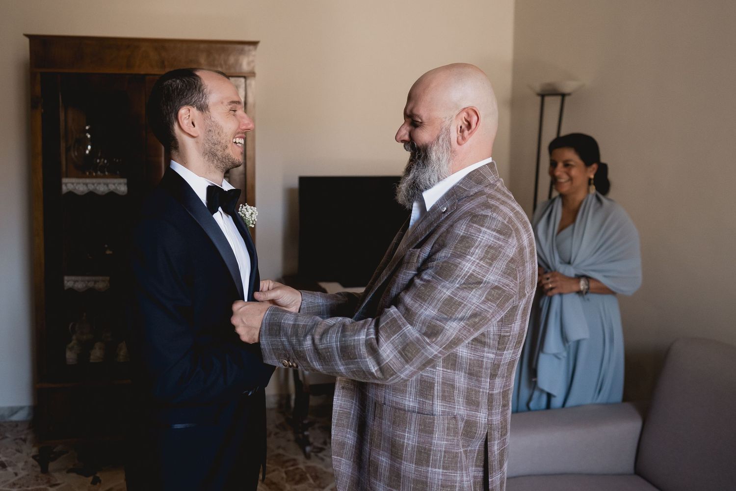 An emotional pre-wedding interaction between family members in formal wear.