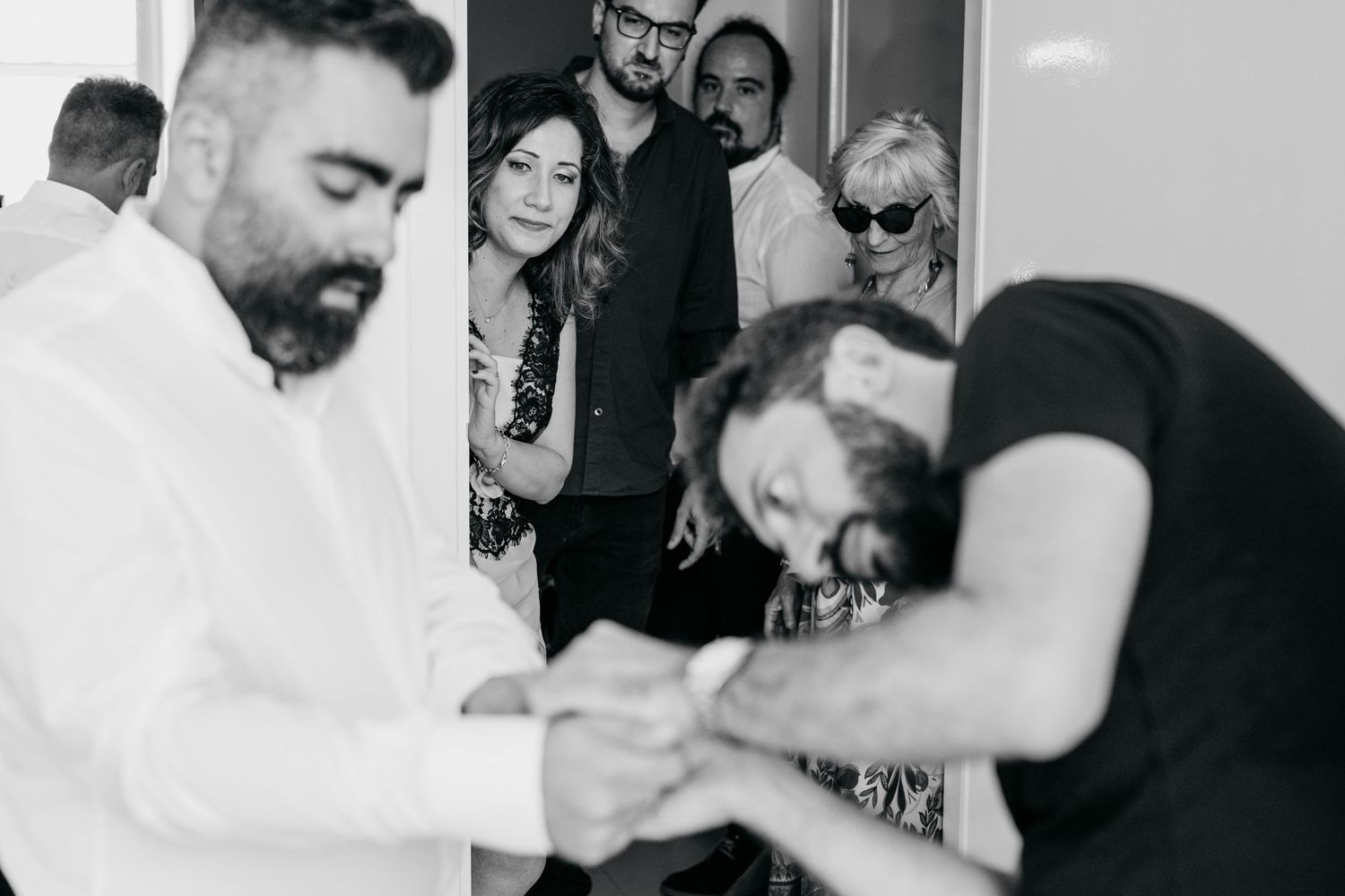 Group of people sharing a lighthearted moment in black and white photography.