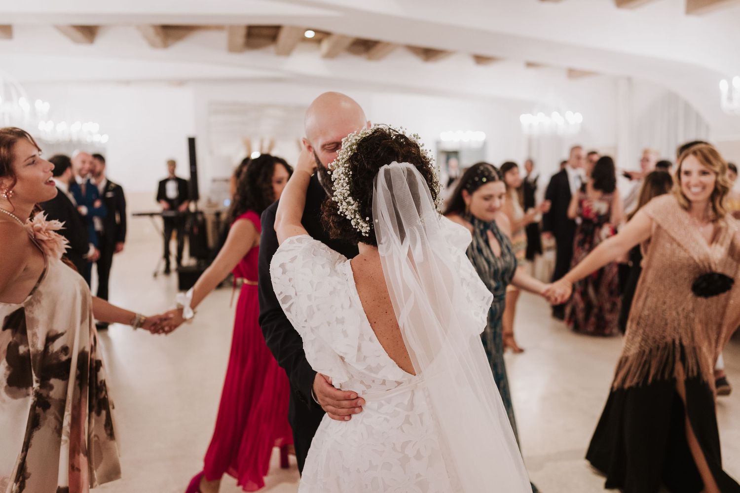 Wedding guests dance together during a lively reception celebration.