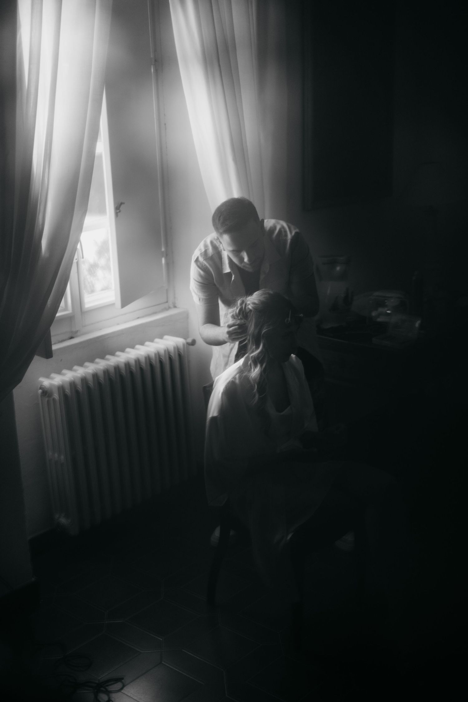 A moody series of black and white photographs showing a figure by a window with dramatic lighting and curtains.