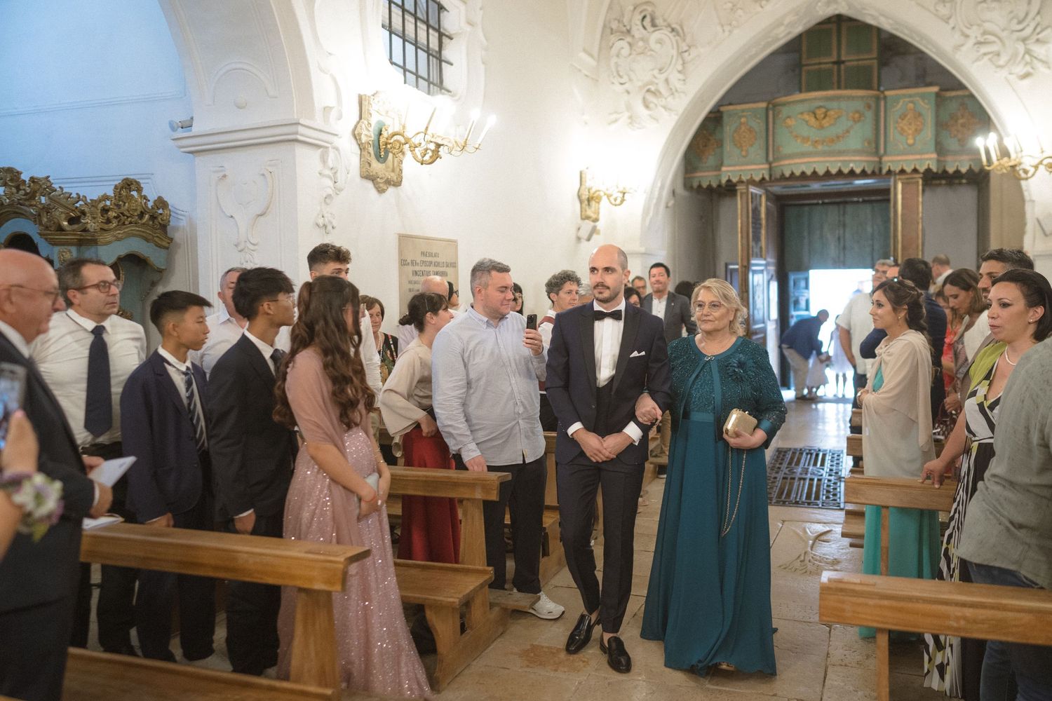 Church interior with vaulted ceilings and guests gathered for a wedding ceremony.