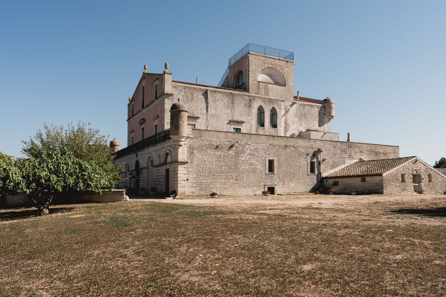 Ancient stone monastery or church building with fortress-like architecture against blue sky.