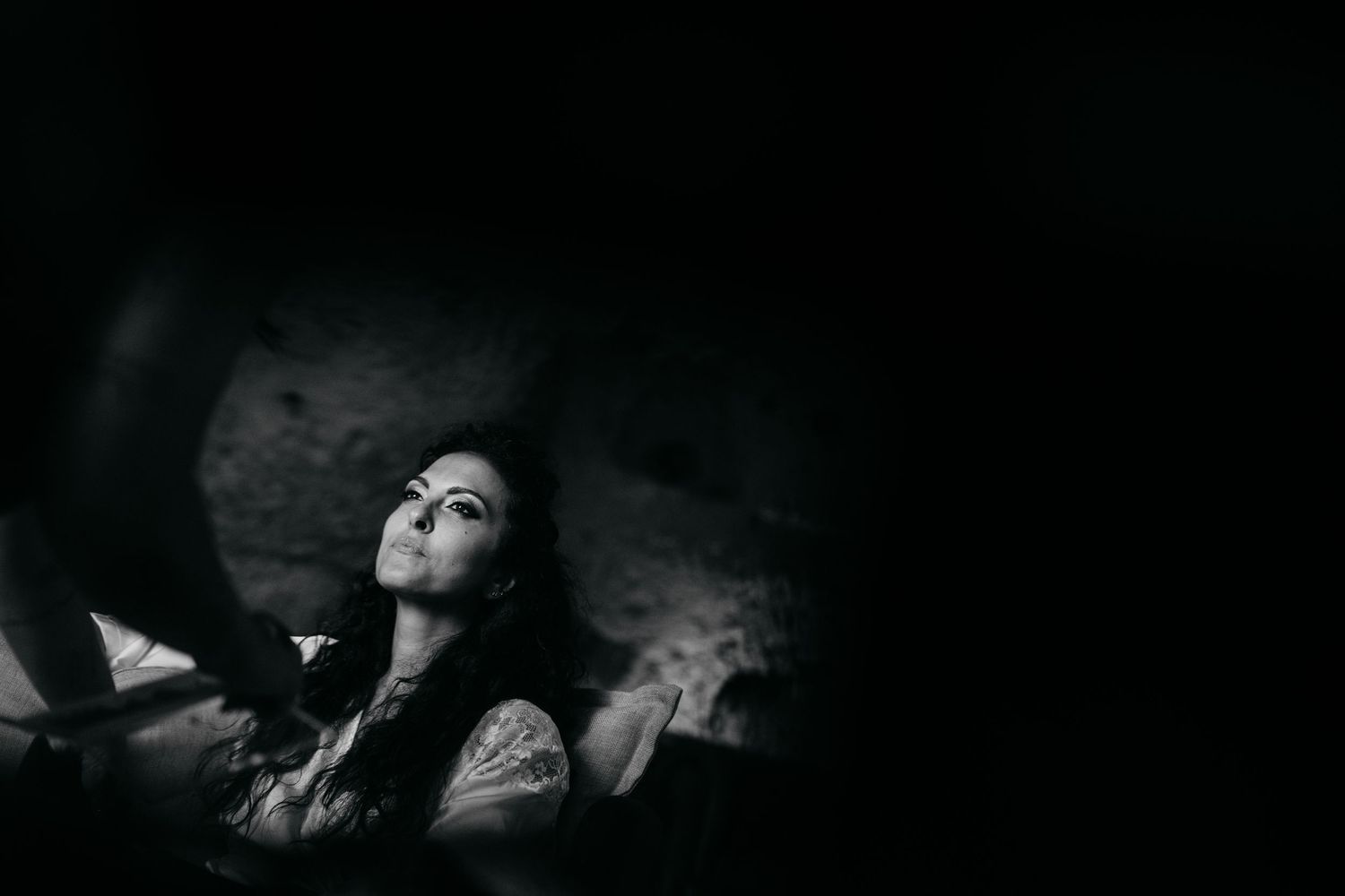A dark and moody artistic photo shows silhouettes against a black background.