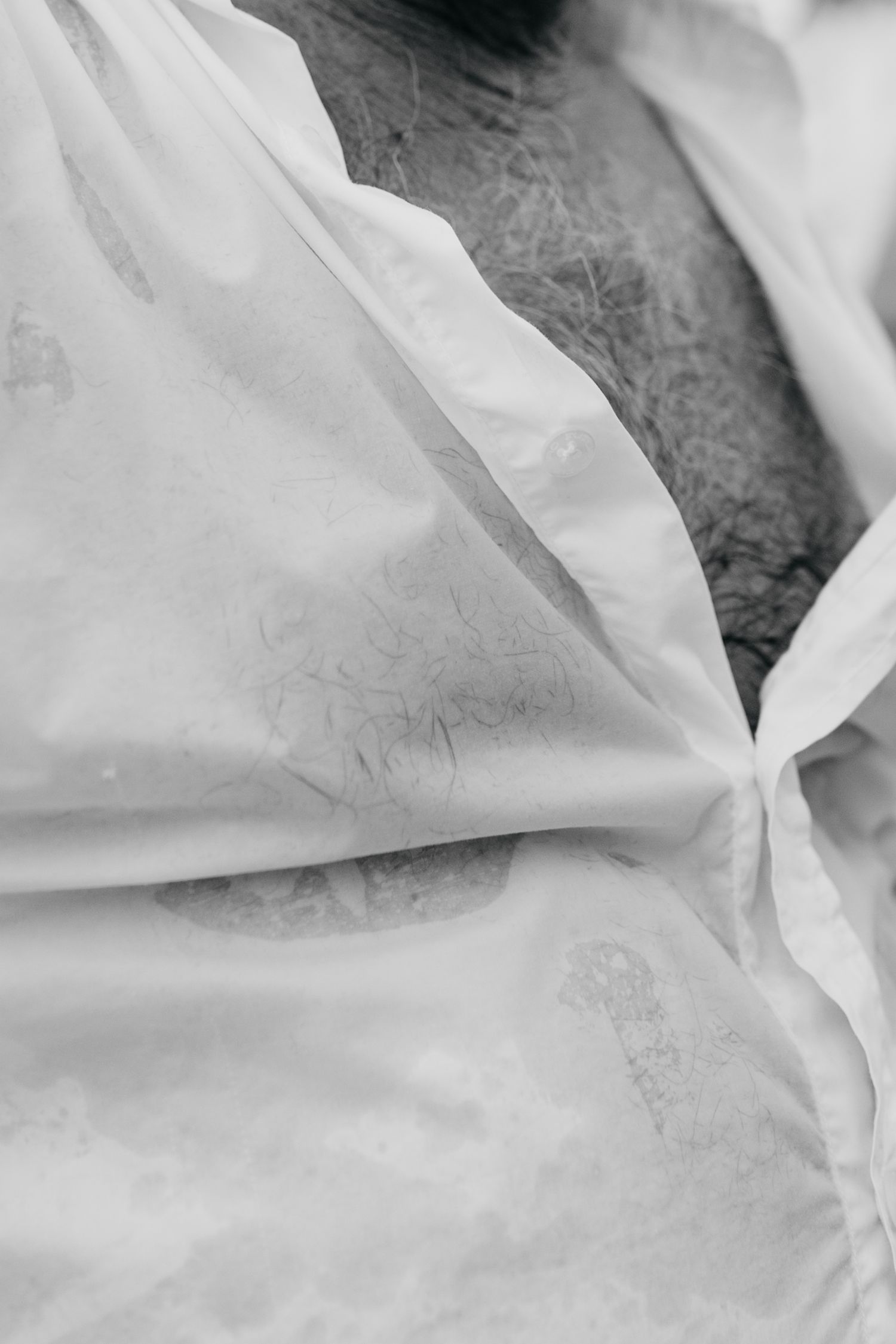 Close-up detail of white wedding dress fabric texture in black and white.