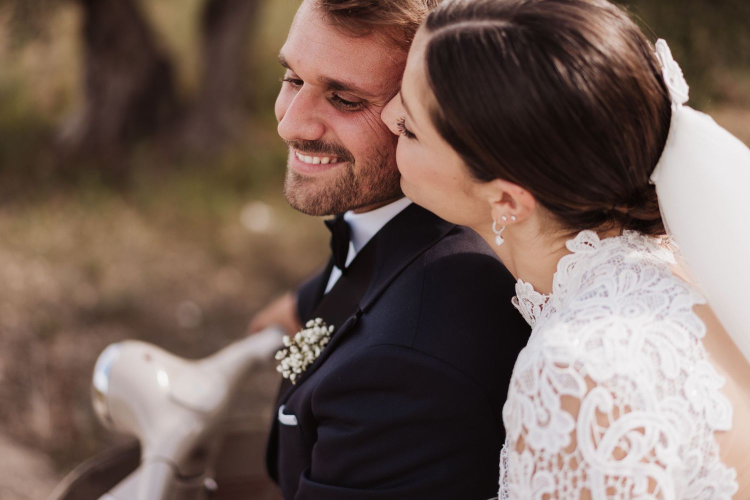 Intimate moment shared between newlyweds during outdoor portrait session.