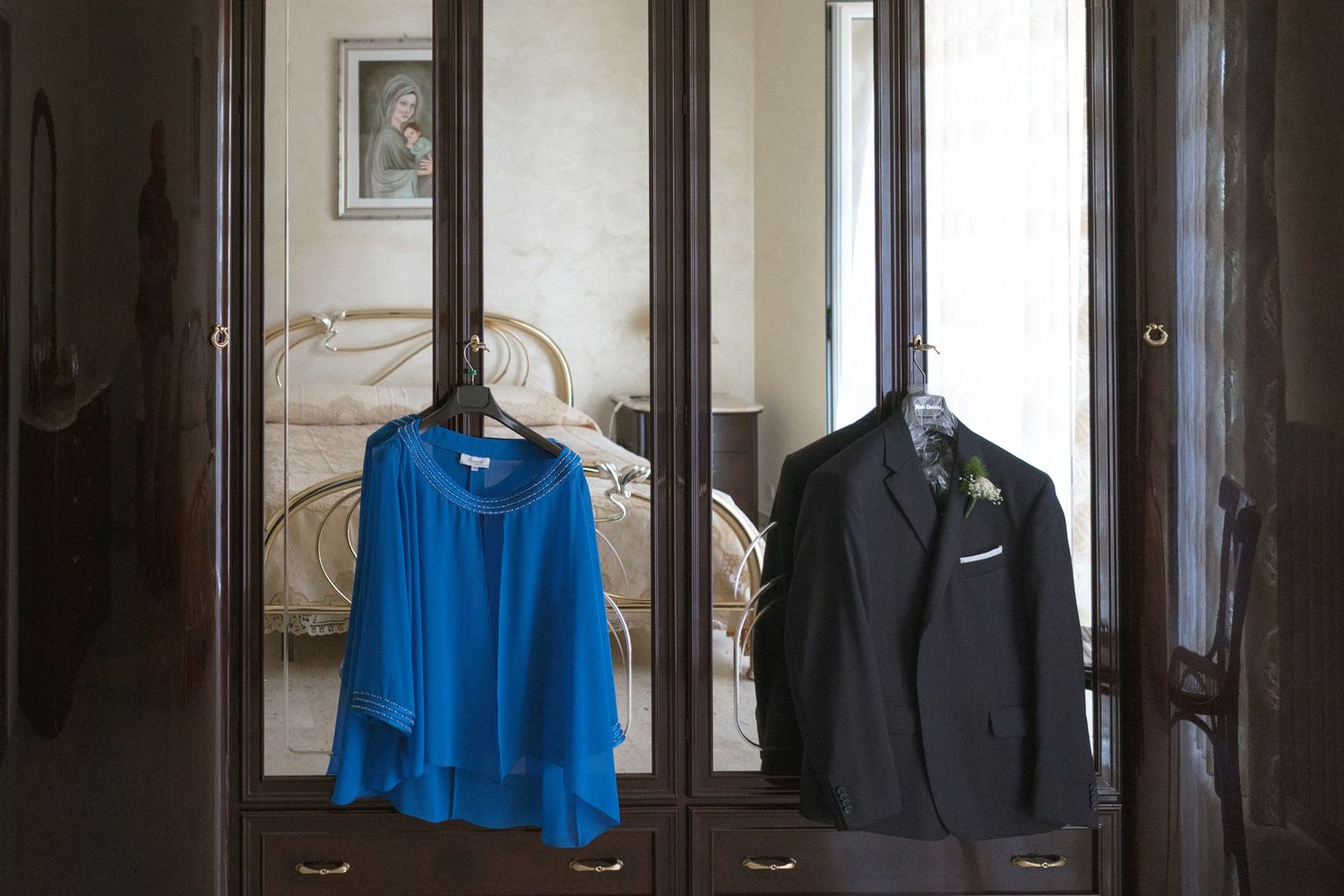 A row of dark suits and formal clothing hanging on a clothing rack in a retail store.