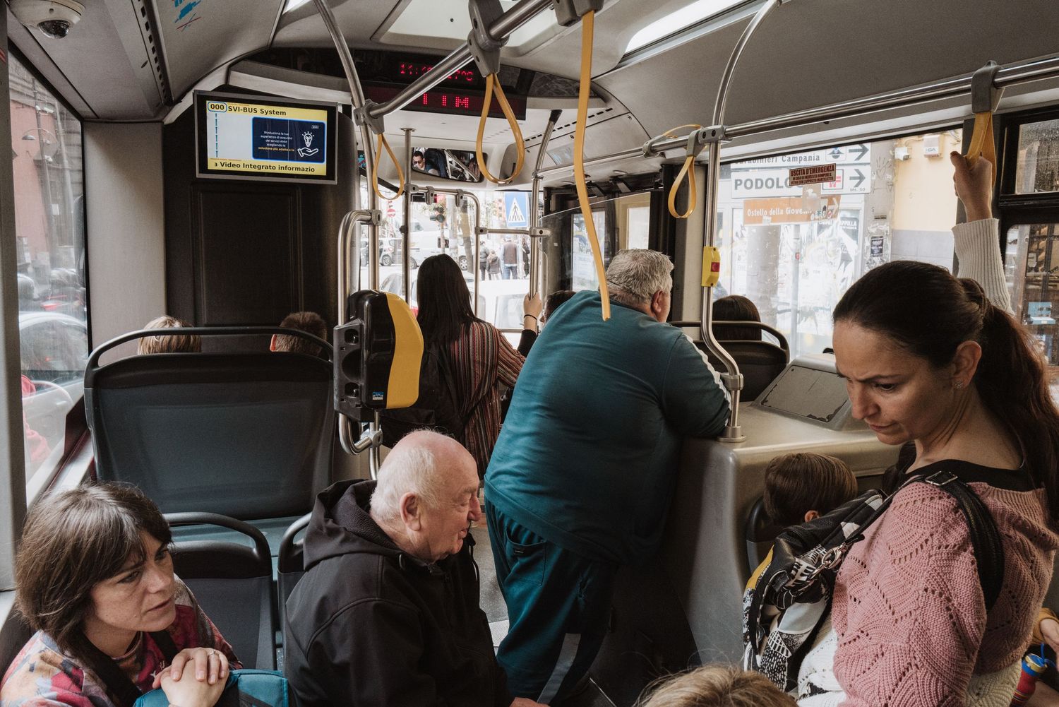 Passengers riding on a public transit bus during a daily commute in an urban setting.
