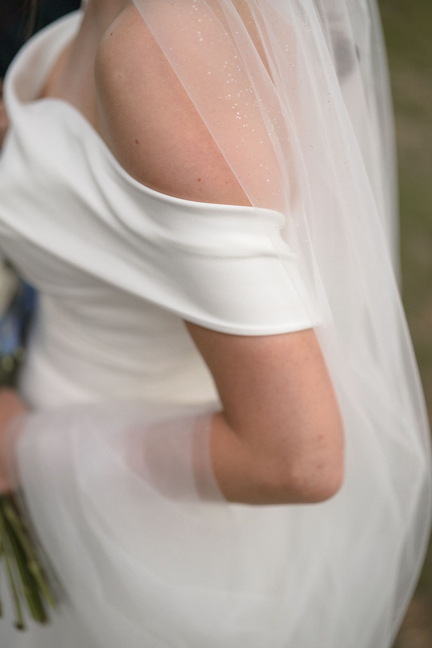 Detail shots of a classic white wedding dress with delicate veil and cap sleeves.