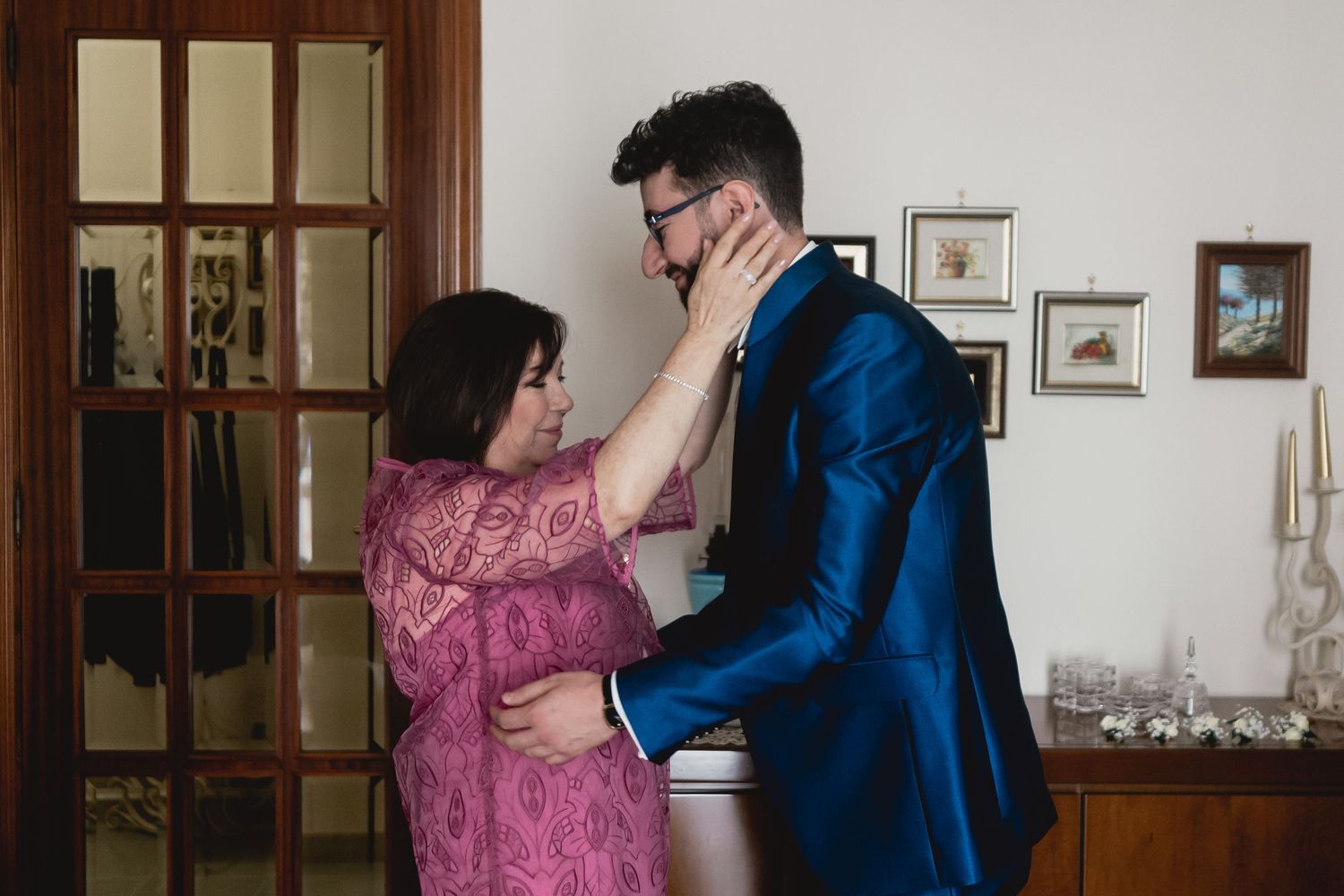 An emotional pre-wedding getting ready moment in an indoor setting with light from a window.