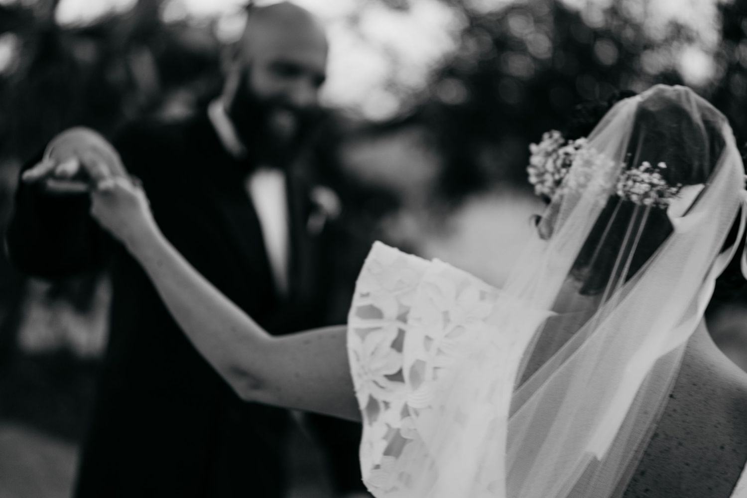 A black and white candid moment of dancing at a wedding celebration.