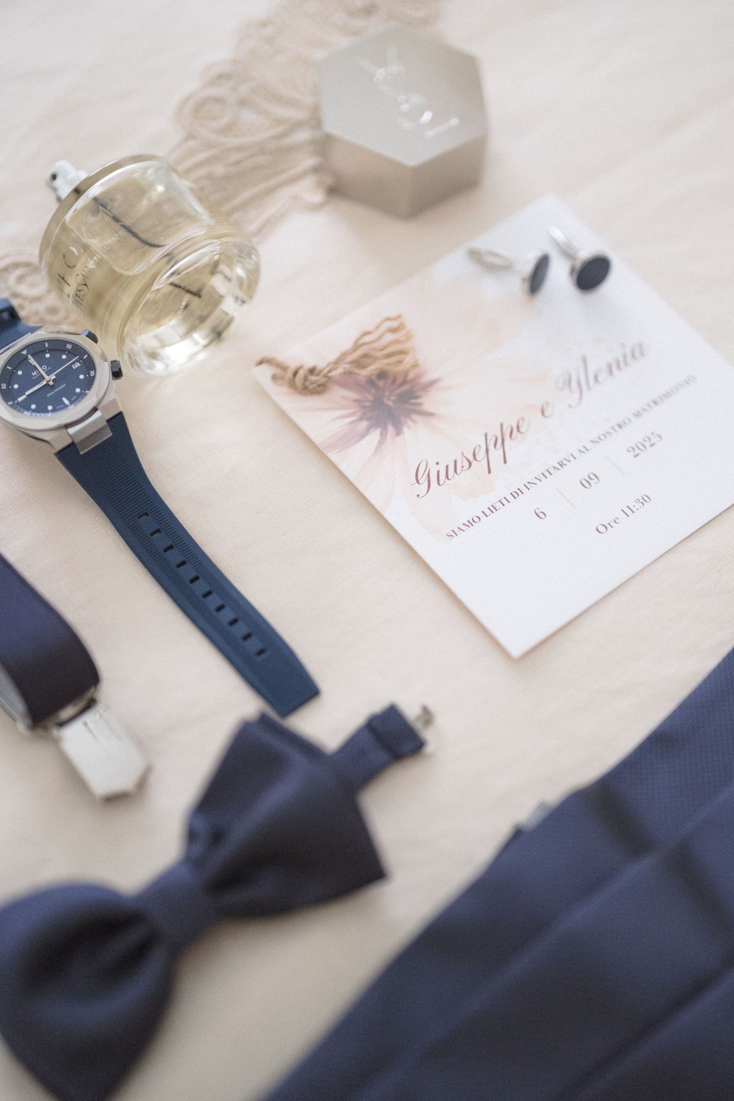 Navy blue bow ties and watches displayed with elegant name cards on a light surface.