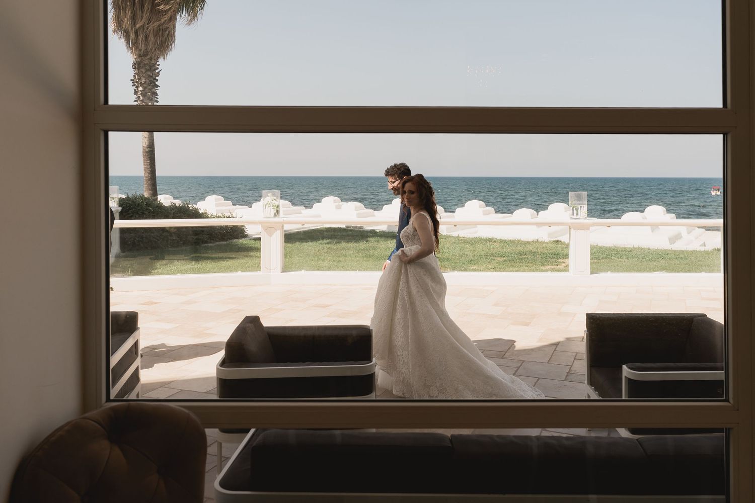 A seaside wedding scene with white balustrades and crashing waves in the background.