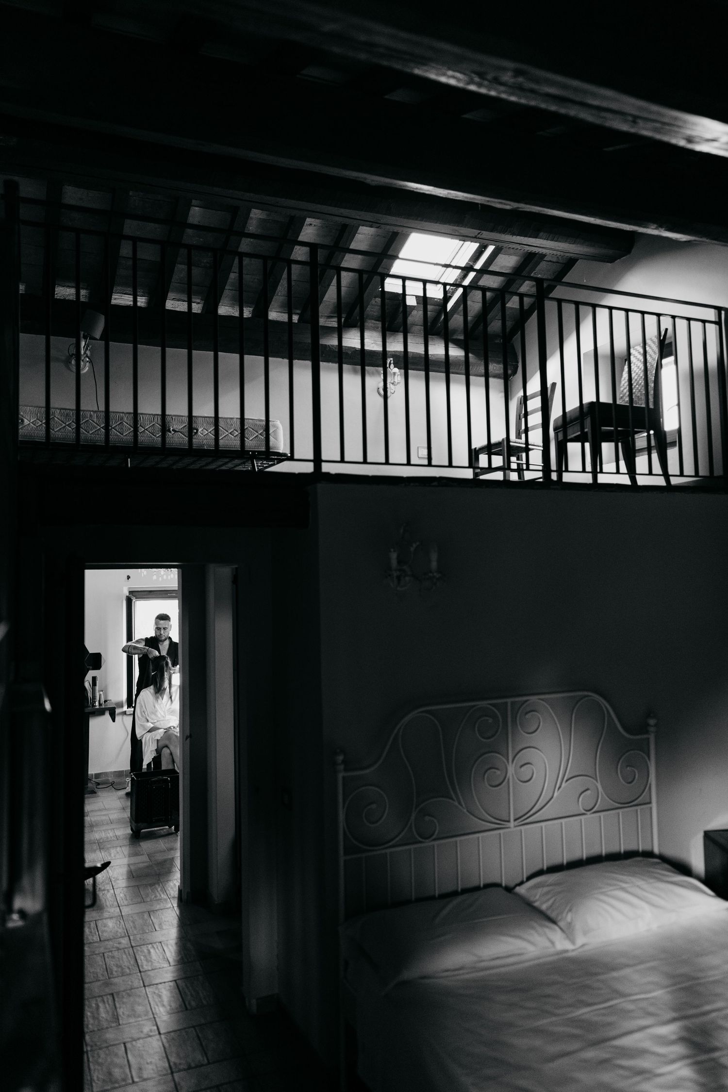 Dark interior hallway with dramatic shadows and light patterns streaming through a metal railing.
