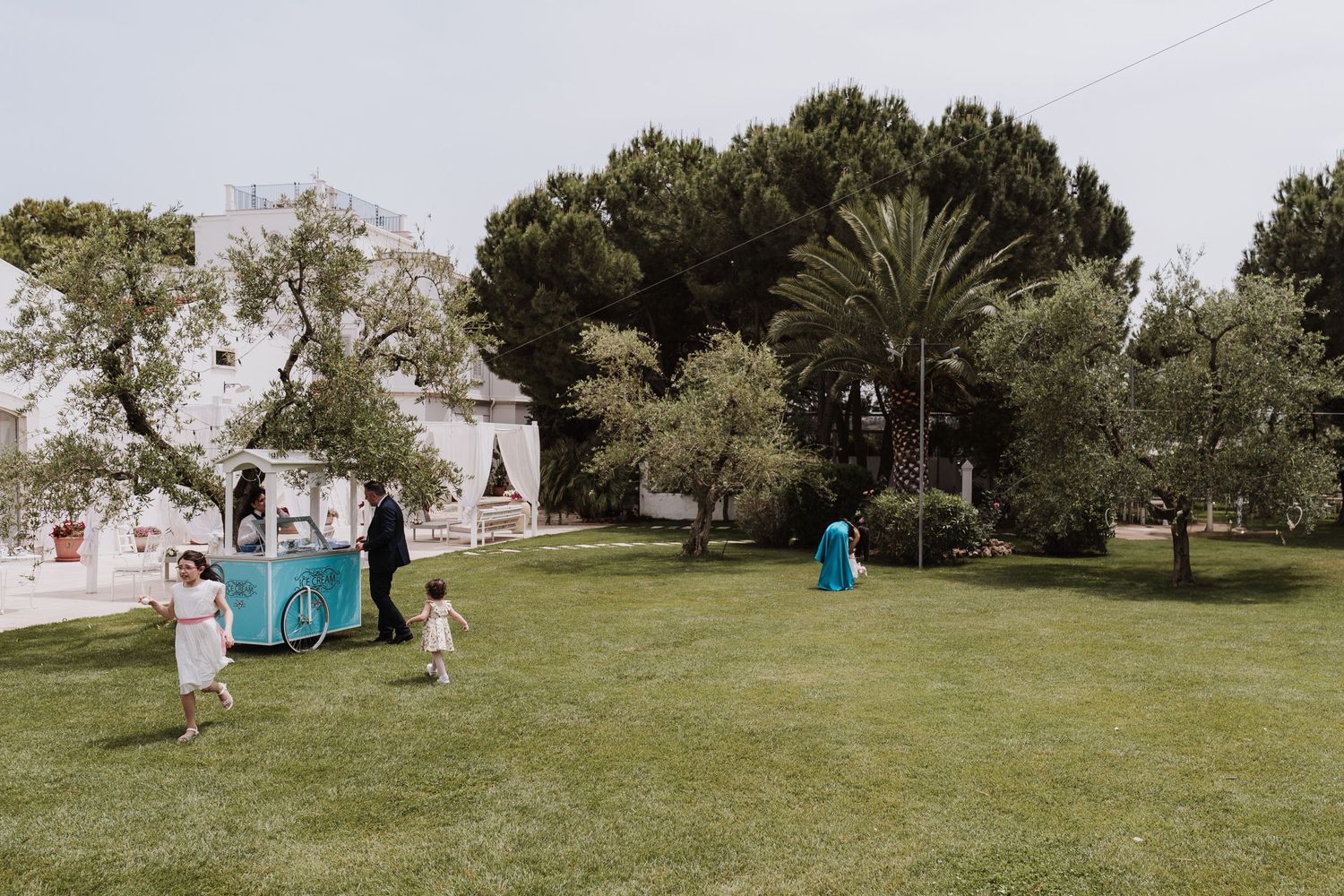 Outdoor venue with blue food cart and white architecture surrounded by green landscaping.