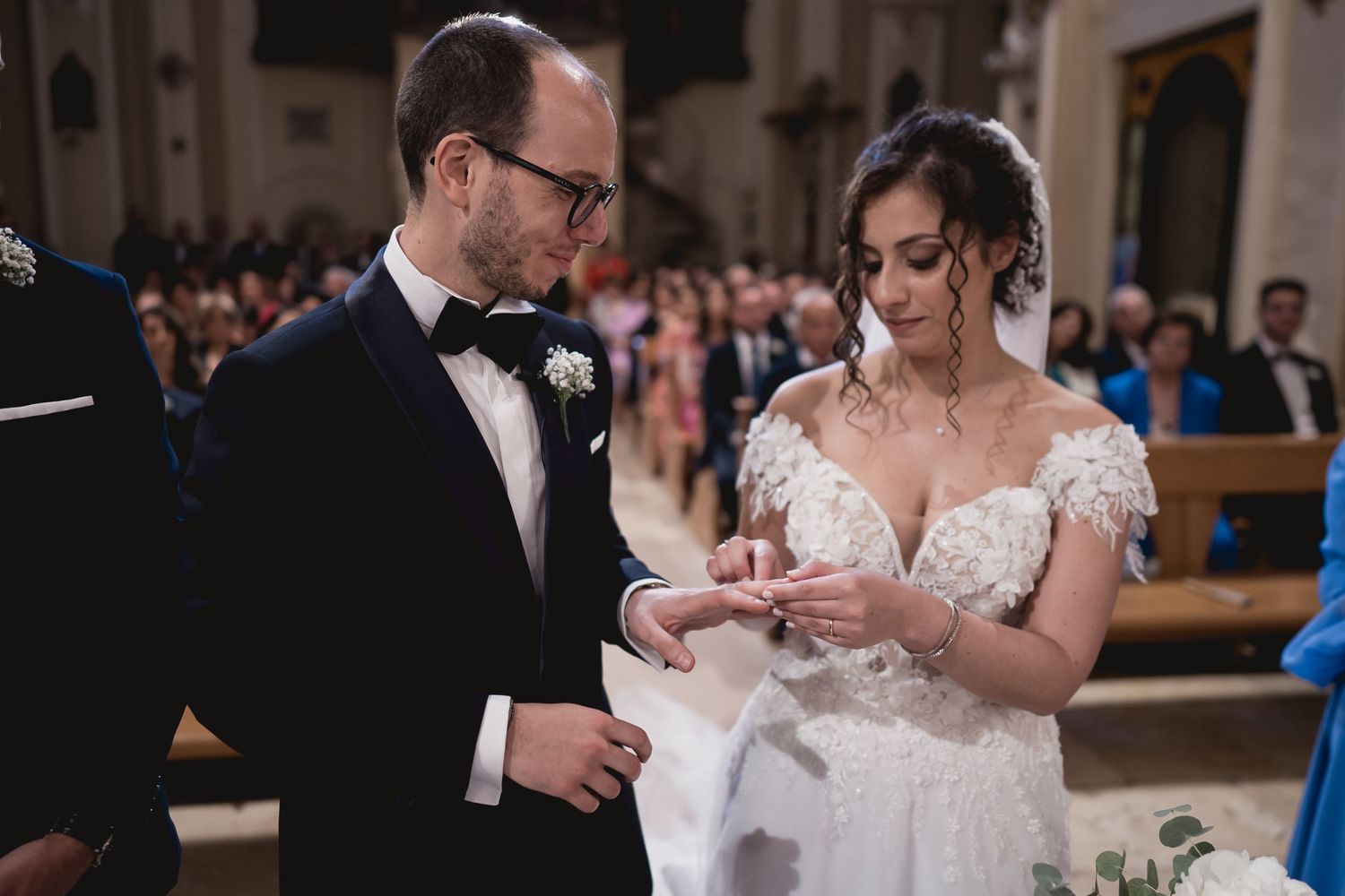 Wedding ceremony exchange in a traditional church setting with elegant decor.