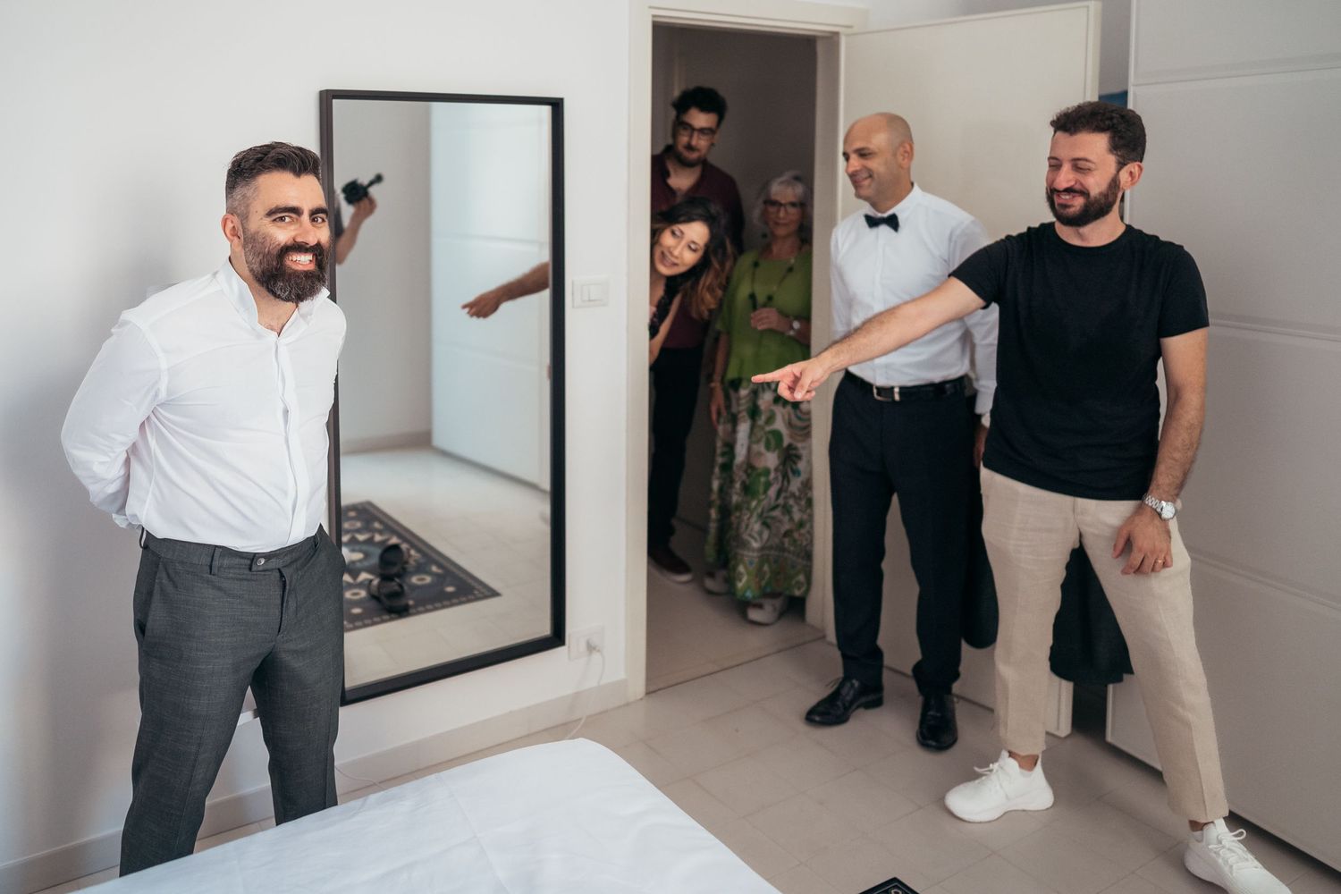 People gathered in a modern bright interior space during wedding preparations.