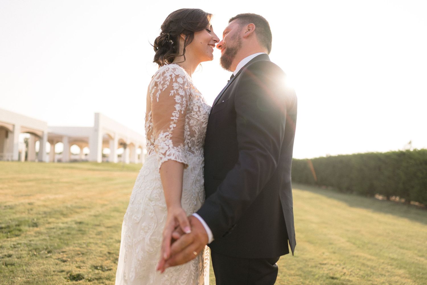 Romantic sunset wedding portraits in an outdoor field with golden light.